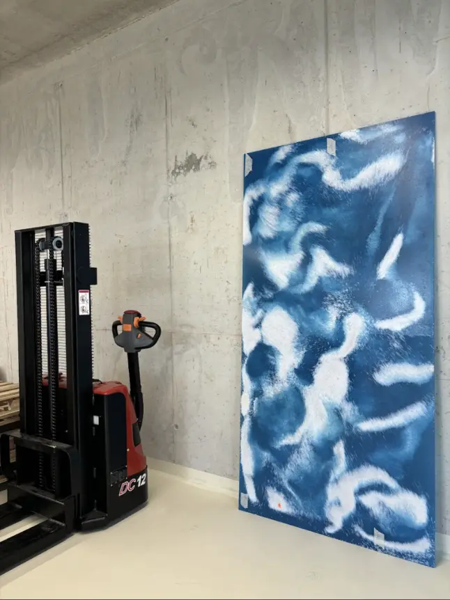 weiß-blau gefleckte Paneele, links davon ein Hubwagen