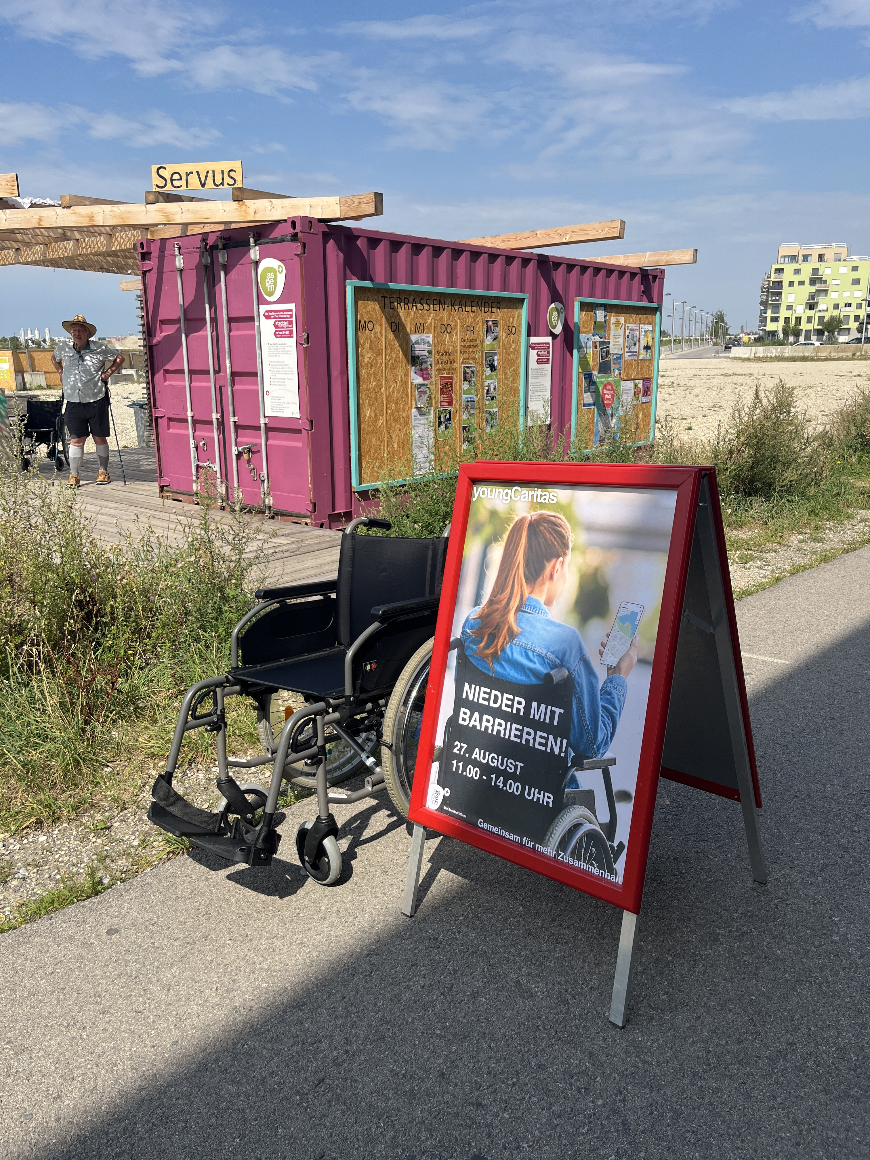 ein Rollstuhl steht neben einem Aufsteller