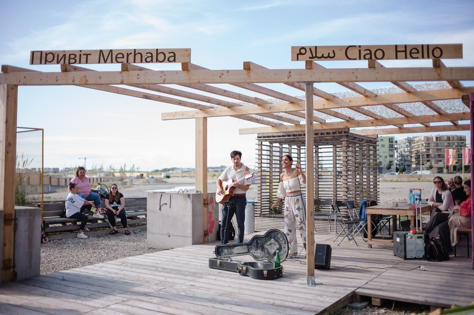 Zwei Menschn stehn auf einer Terrasse und machen Musik