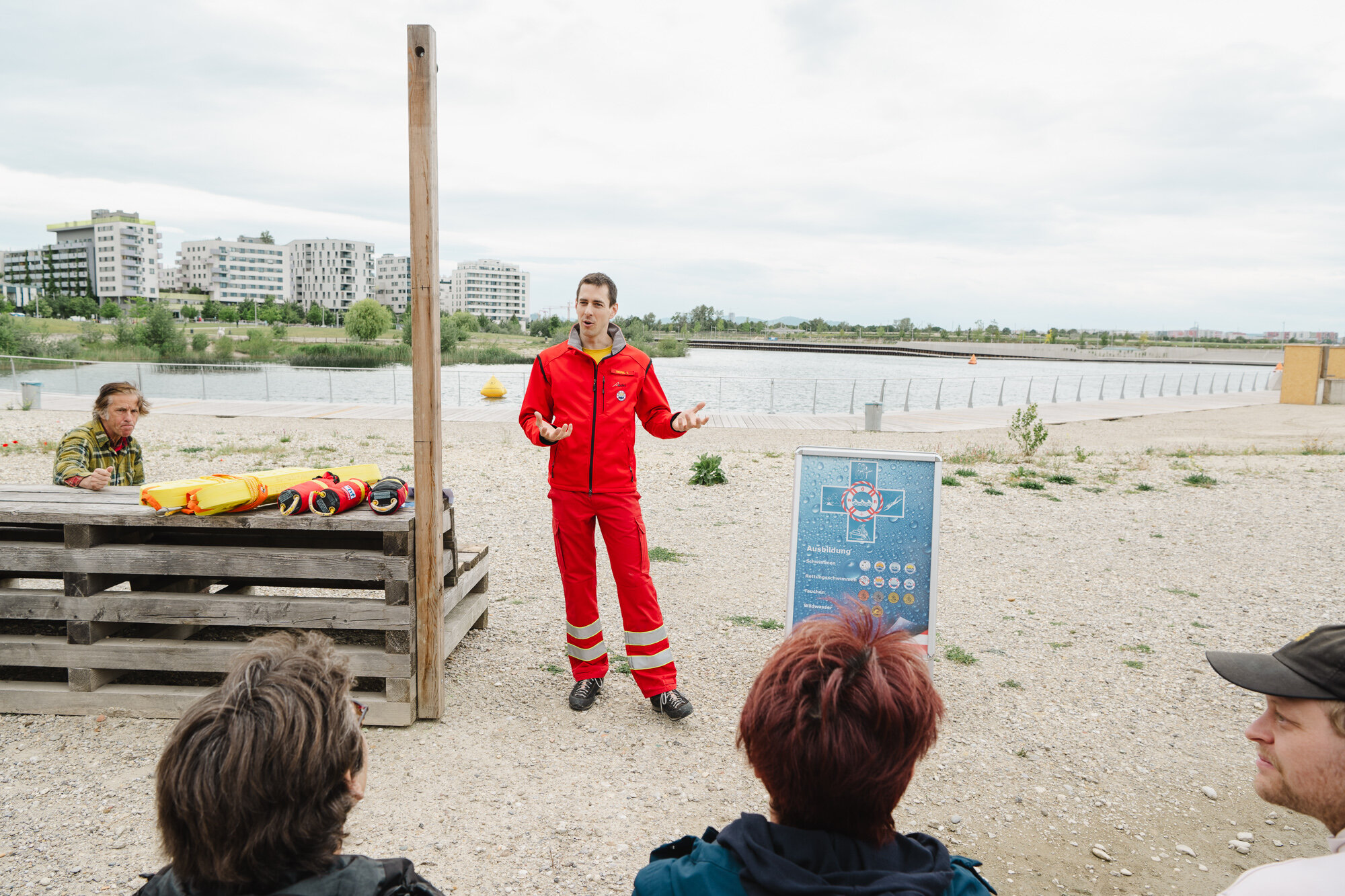 ein Mann in roter Uniform steht vor Menschen und erzählt etwas
