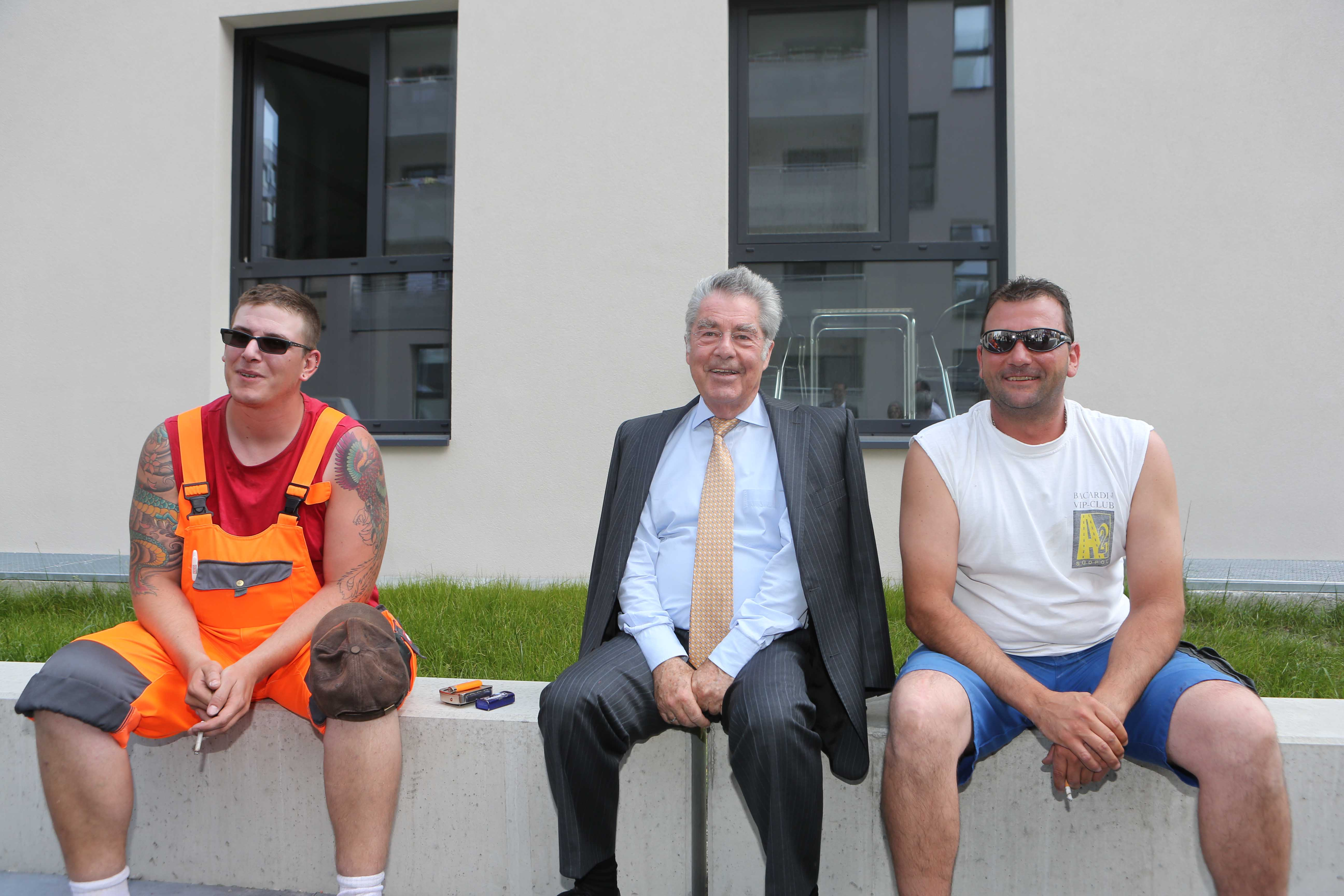 Menschen sitzen auf einer Mauer