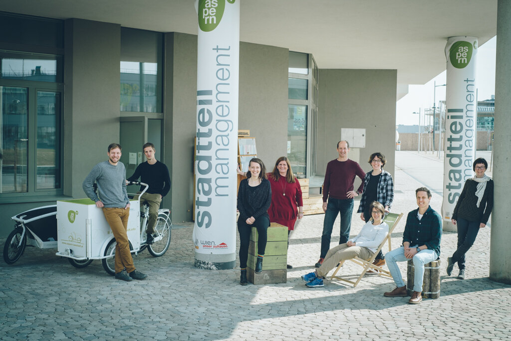 Menschen stehen verteilt vor einem Gebäude