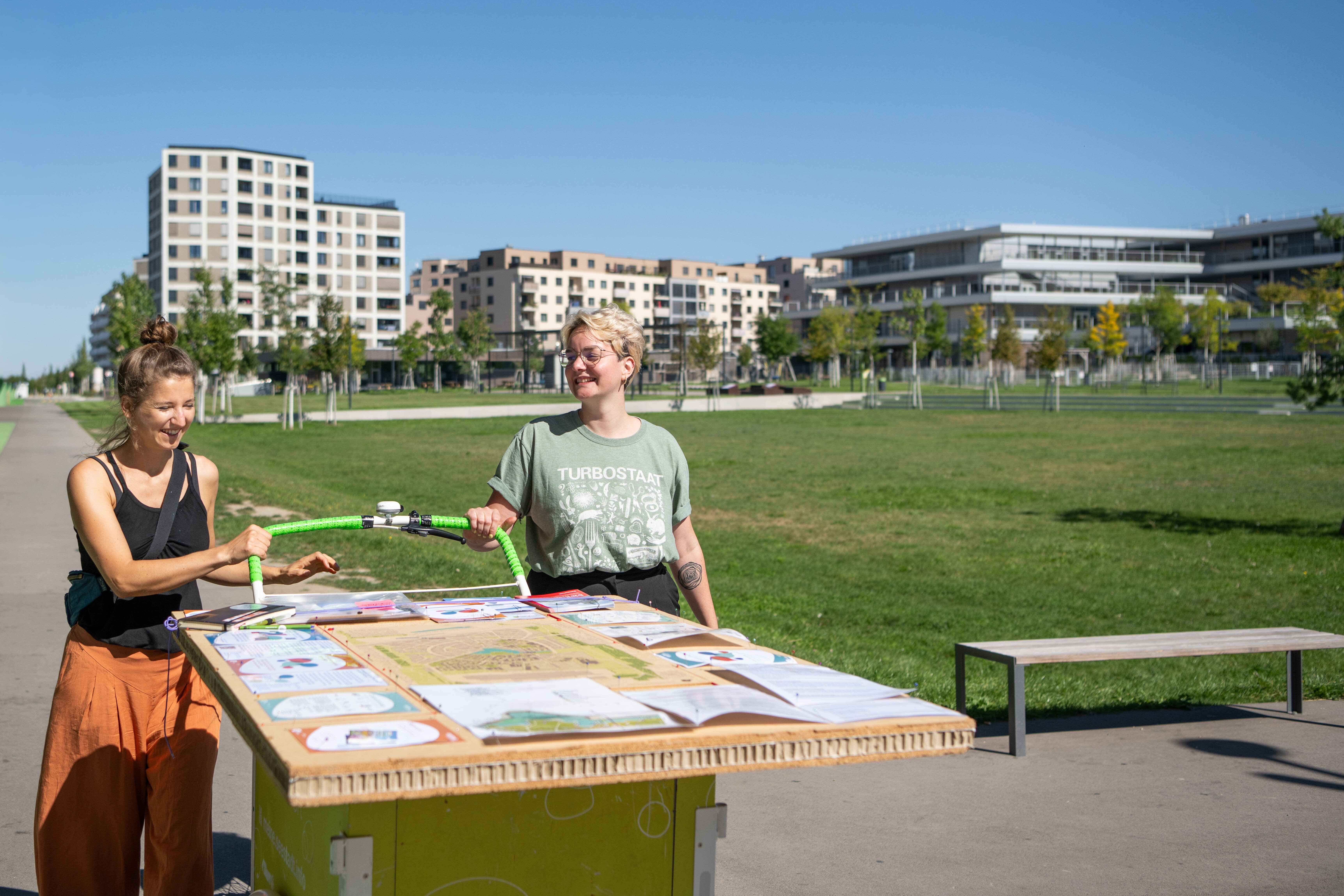 zwei Frauen gehen neben einem Lastenrad