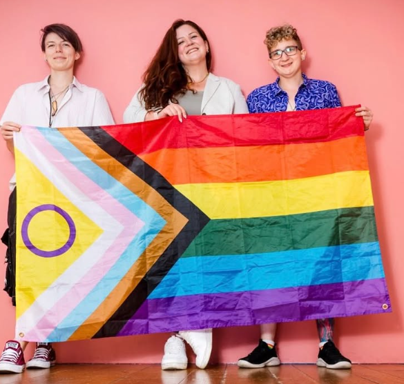 drei menschen halten eine fahne nach oben