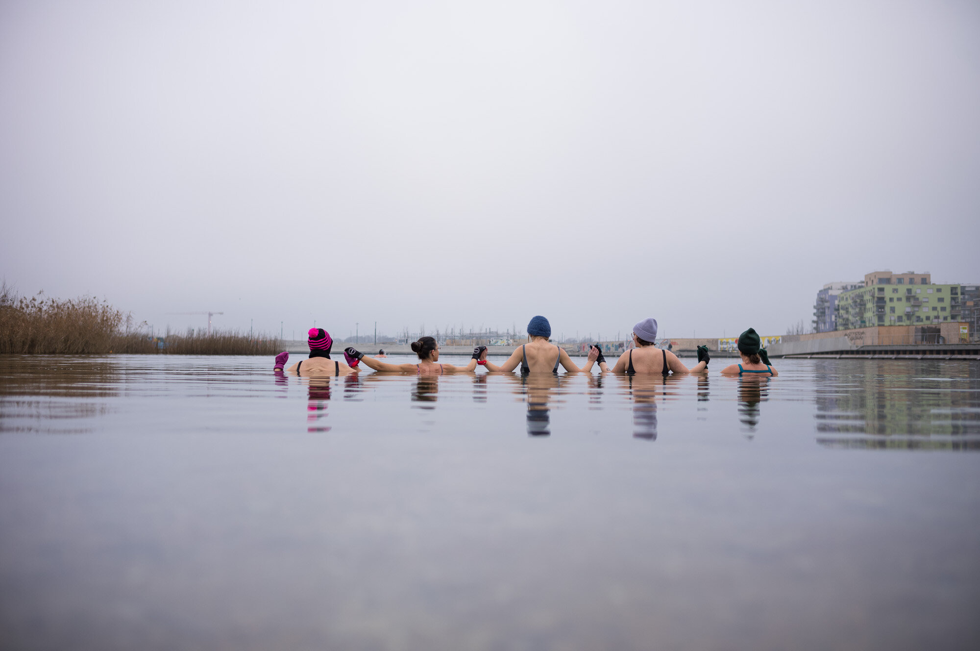 Menschen stehen im See und haben Hauben auf