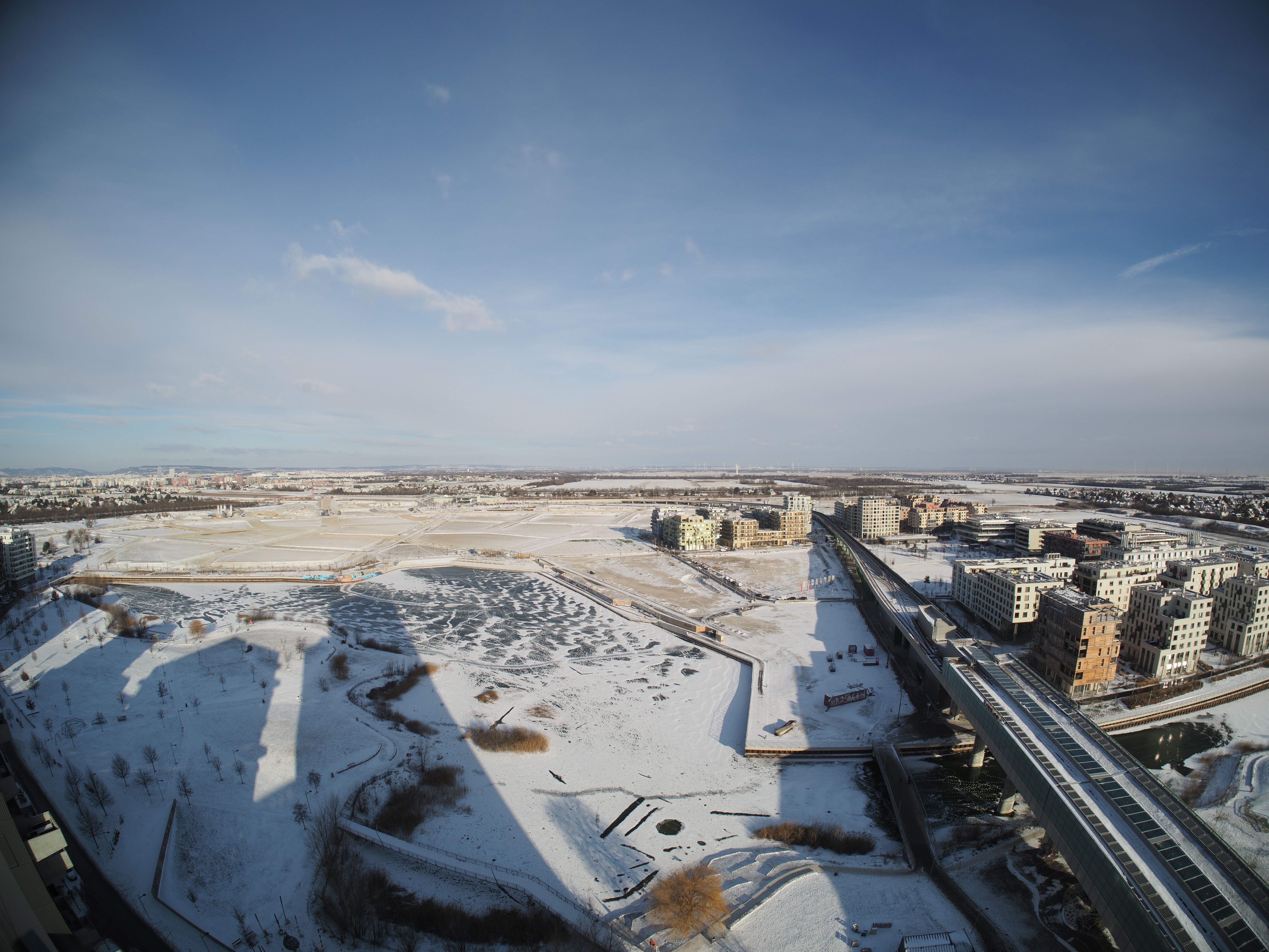 Bild der winterlichen Seestadt von Süden aus mit Fokus auf den zugefrorenen See. 