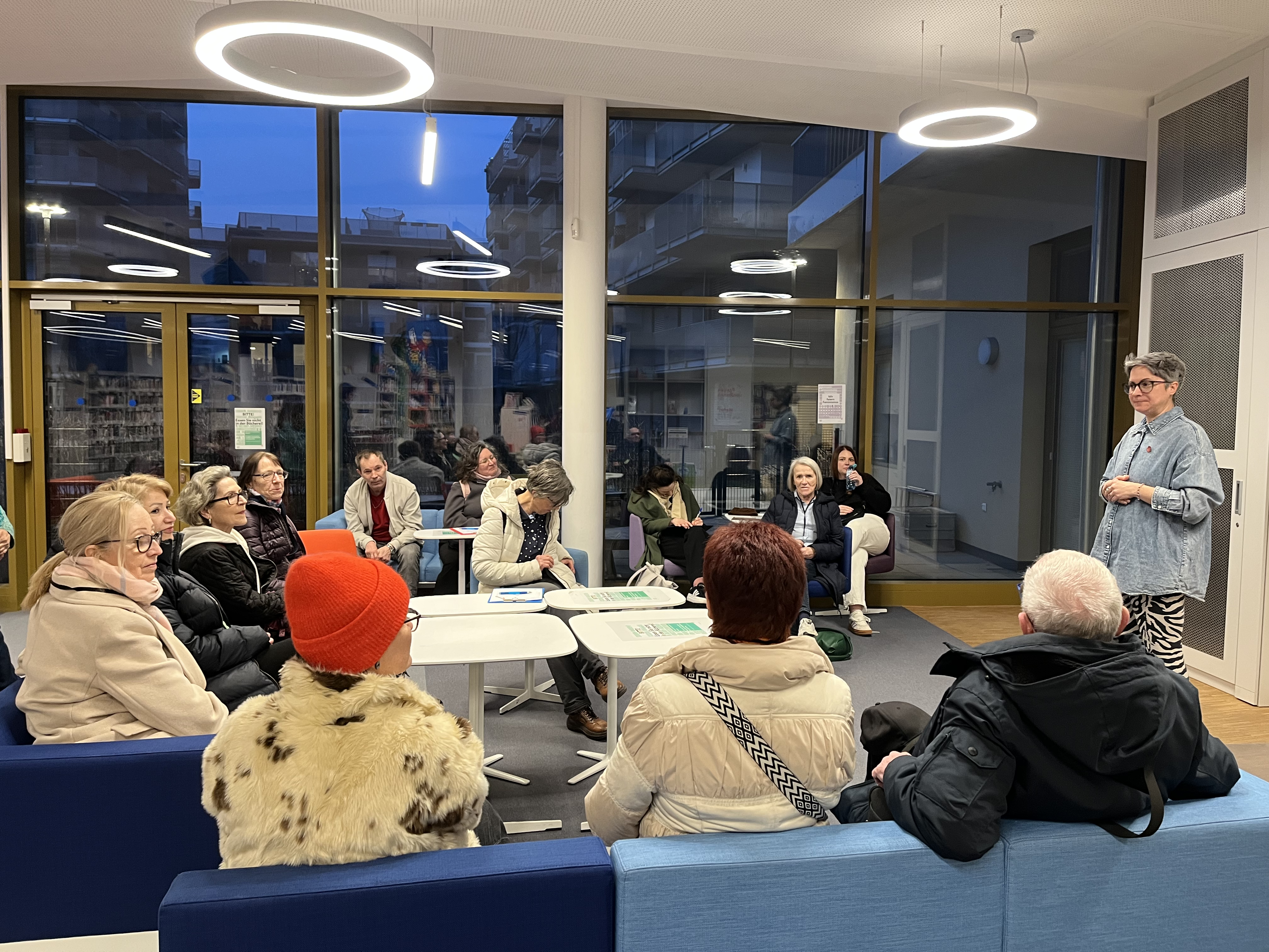 Gruppe von Frauen sitzt in der Bücherei in der Seestadt und hören Vortrag 