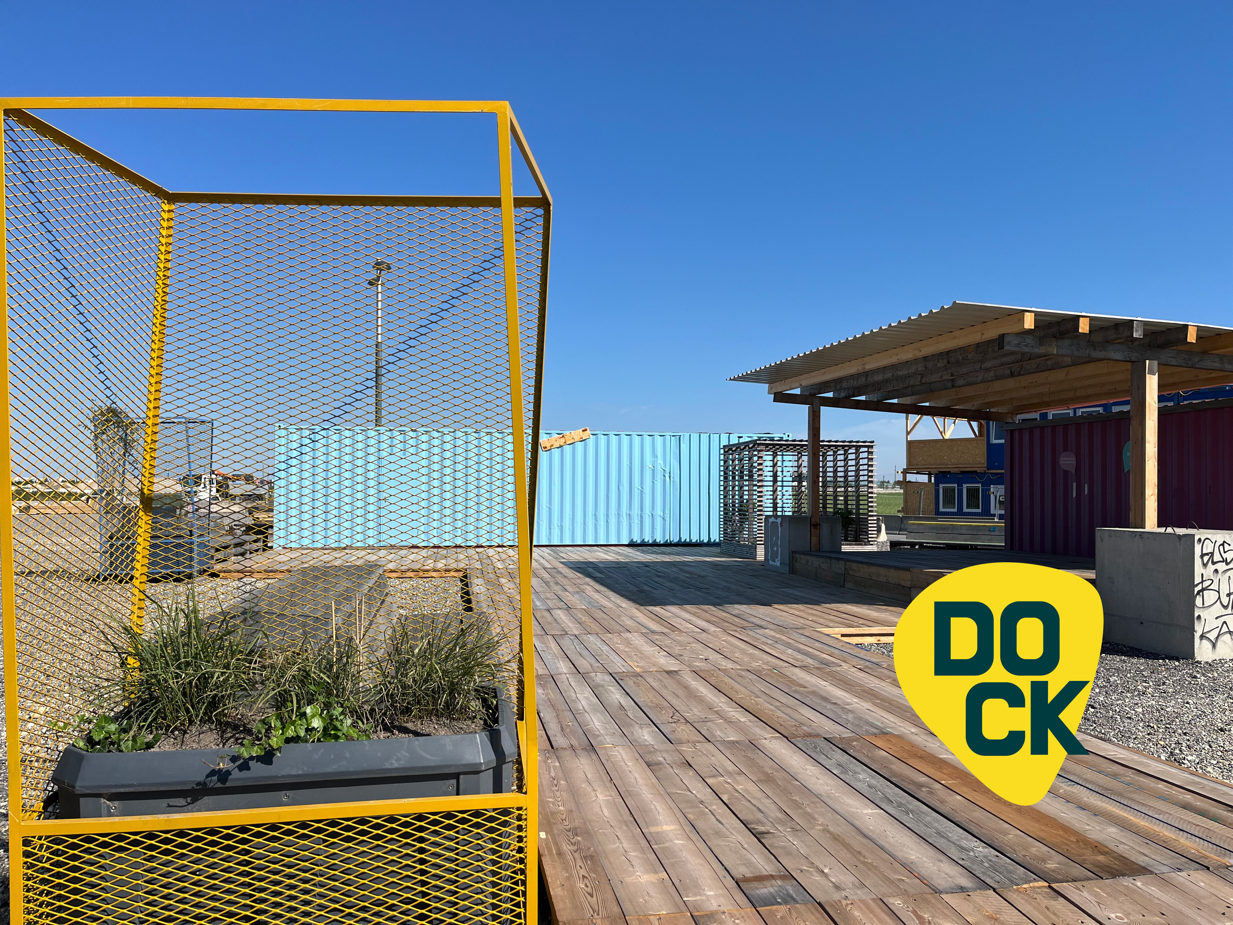 Eine Terrasse mit einem Pflanztopf und ein Container mit einer Überdachung