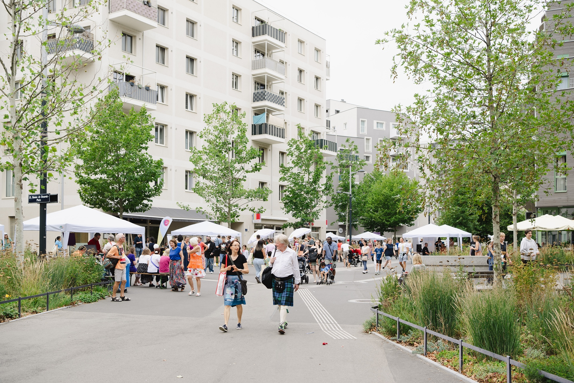 Menschen und Pavillons auf einem Platz in einer Stadt