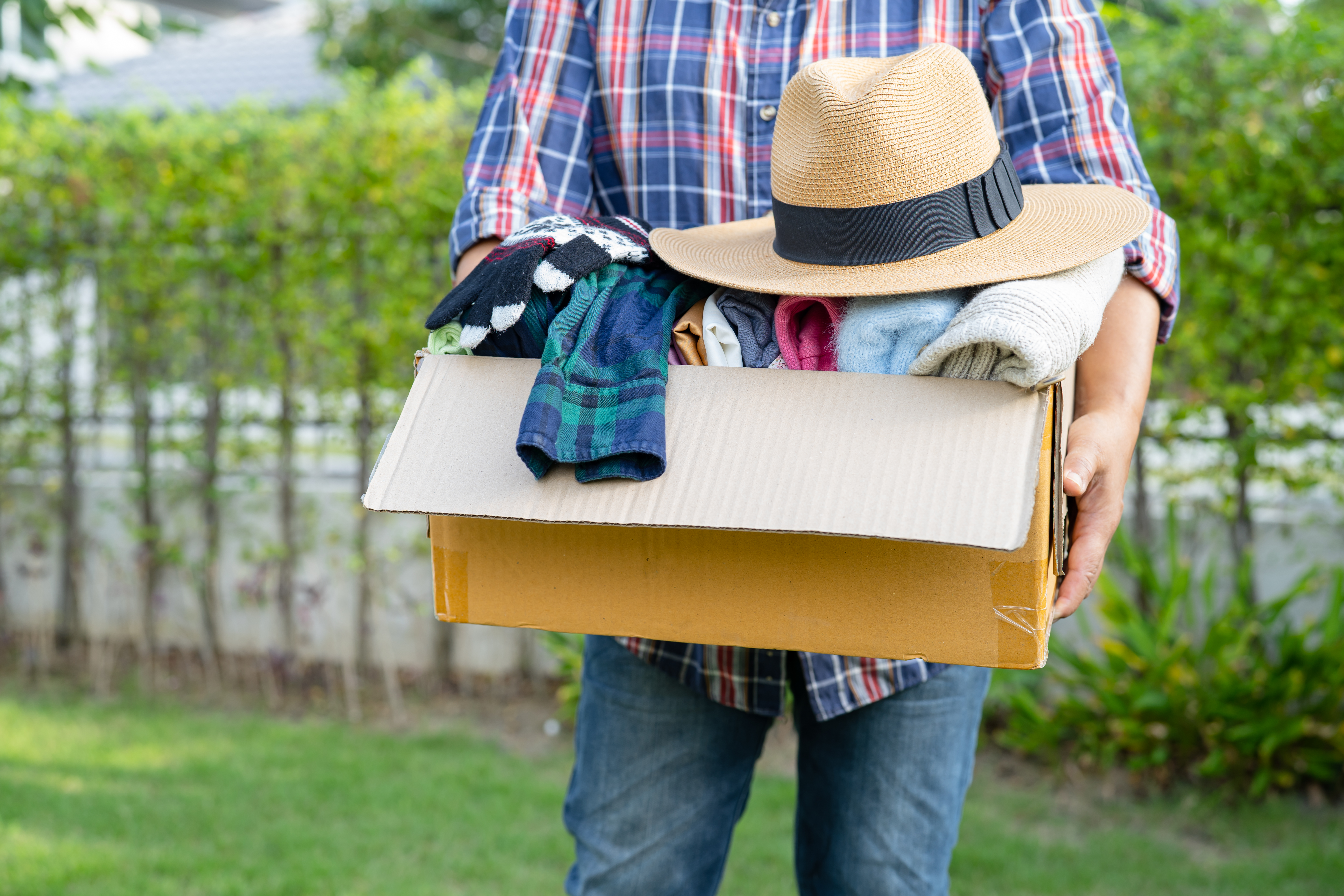 Mann, der eine Box voll mit Kleidung hält