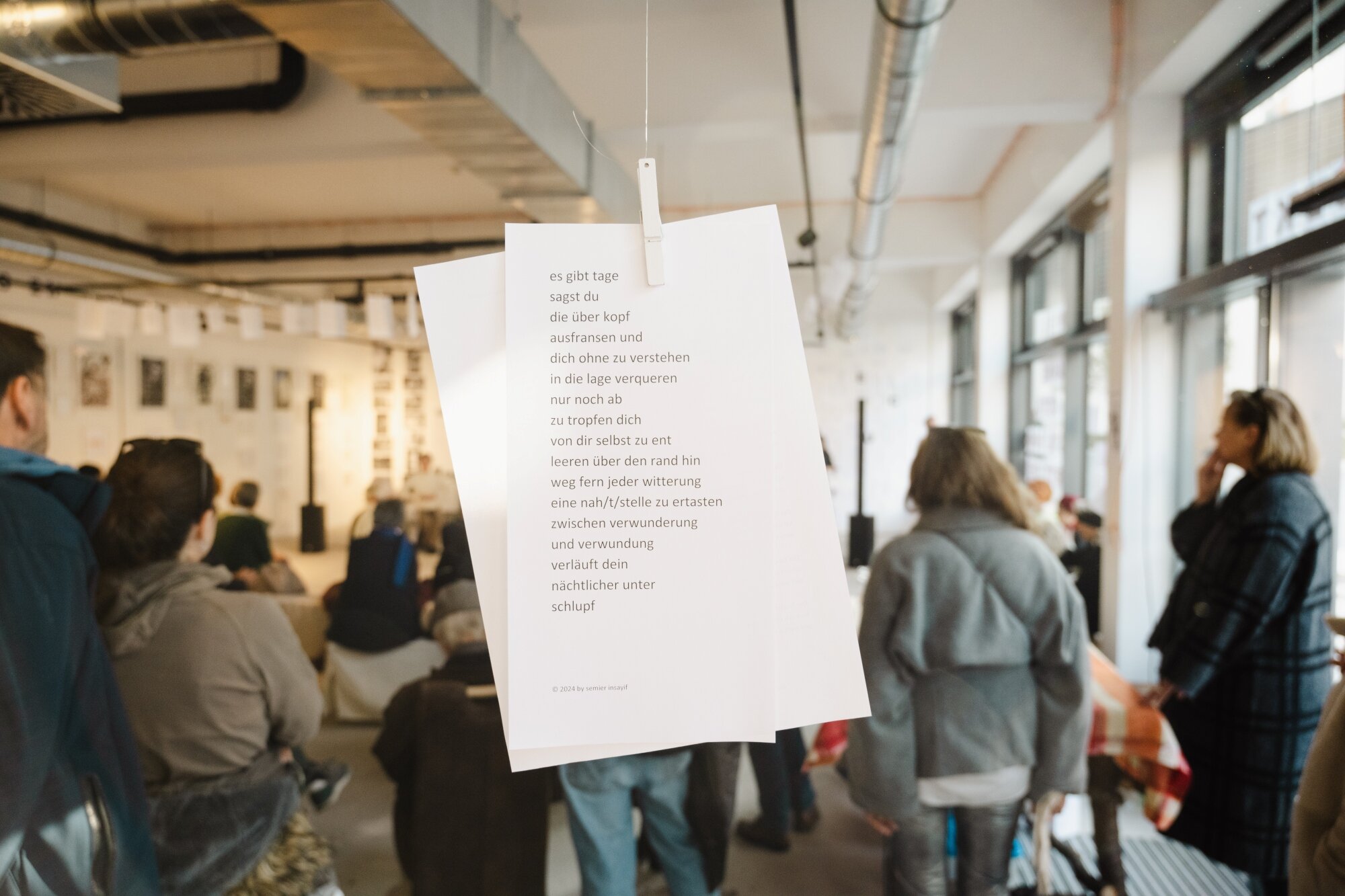 Lyric On Line Ausstellung und Konzert unterschiedliche Manschen hören ein Konzert während einer Ausstellung in einer Galerie im Seeparkquartier aspern Seestadt