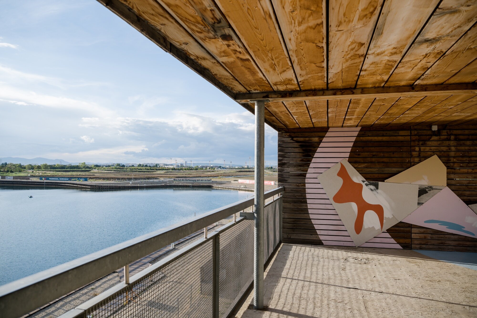 Ausstellung im Flederhaus am See offener Holzbau mit großflächigem Bild mit modernern Kunst mit Blick auf den asperner See
