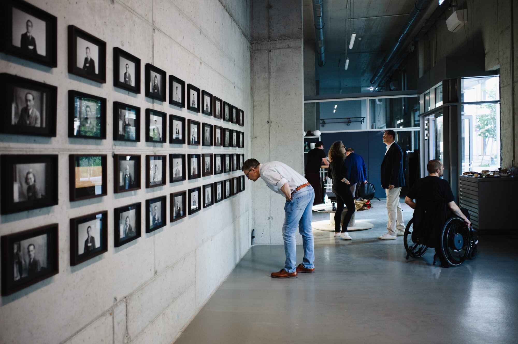 Menschen unterhalten sich oder betrachten Bilder in einem modernen Kunstraum