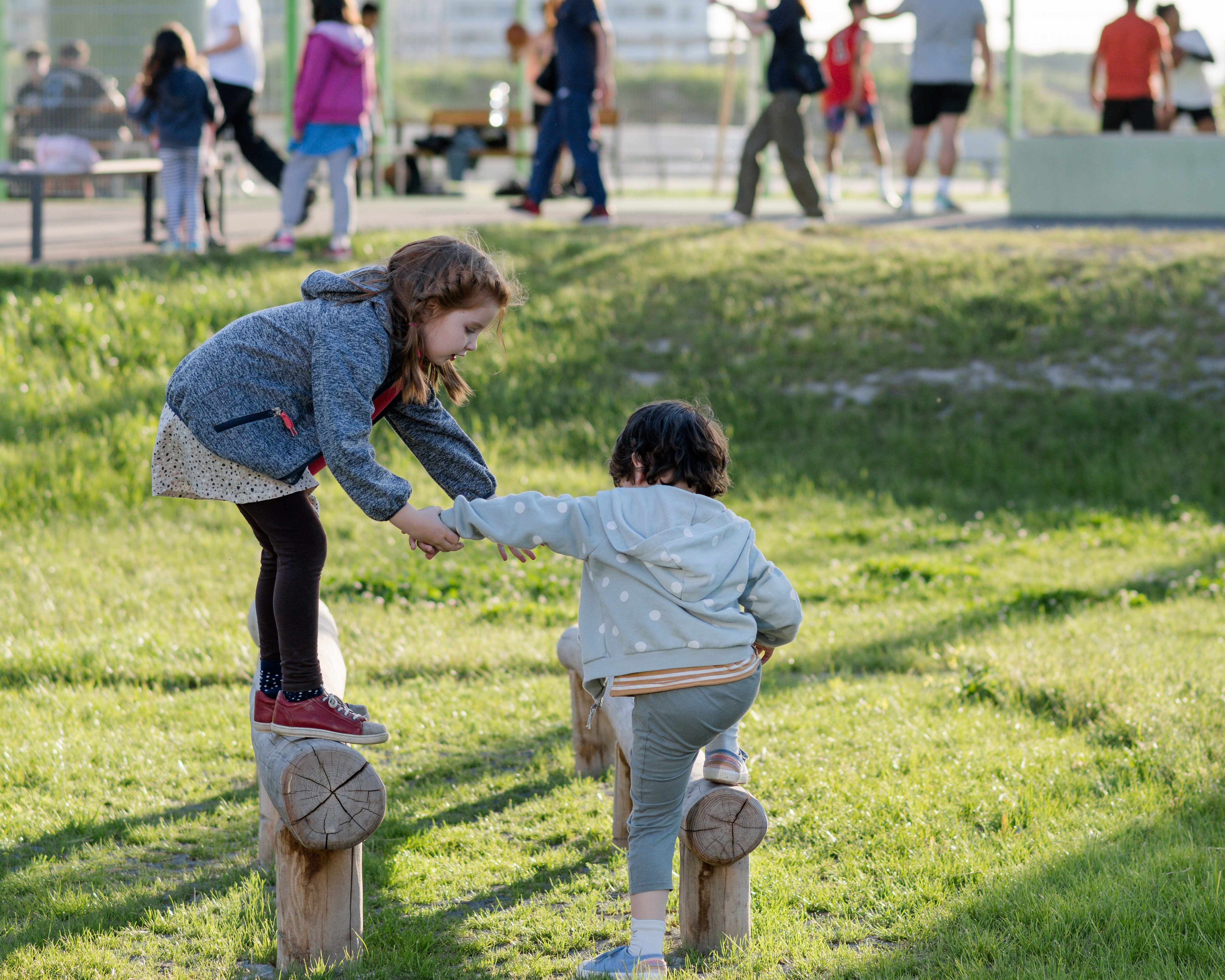 spielende Kinder auf einer Wiese im Park in urbanem Gebiet