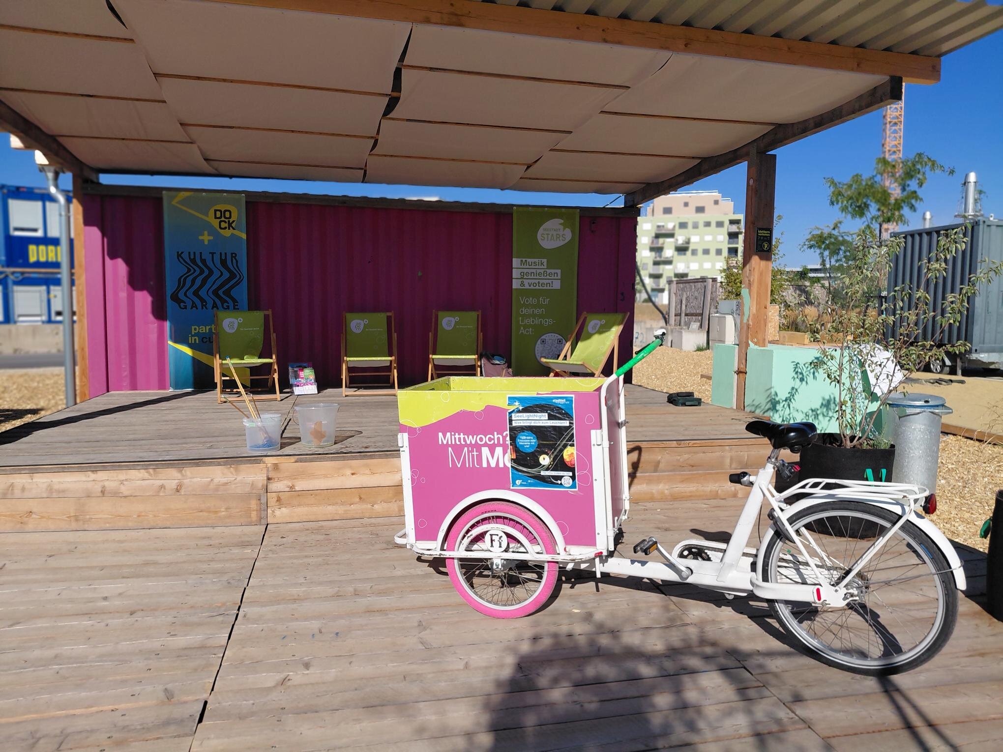 Terrasse für Nachbarschaft DOCK Seestadt mit Grätzlrad davor