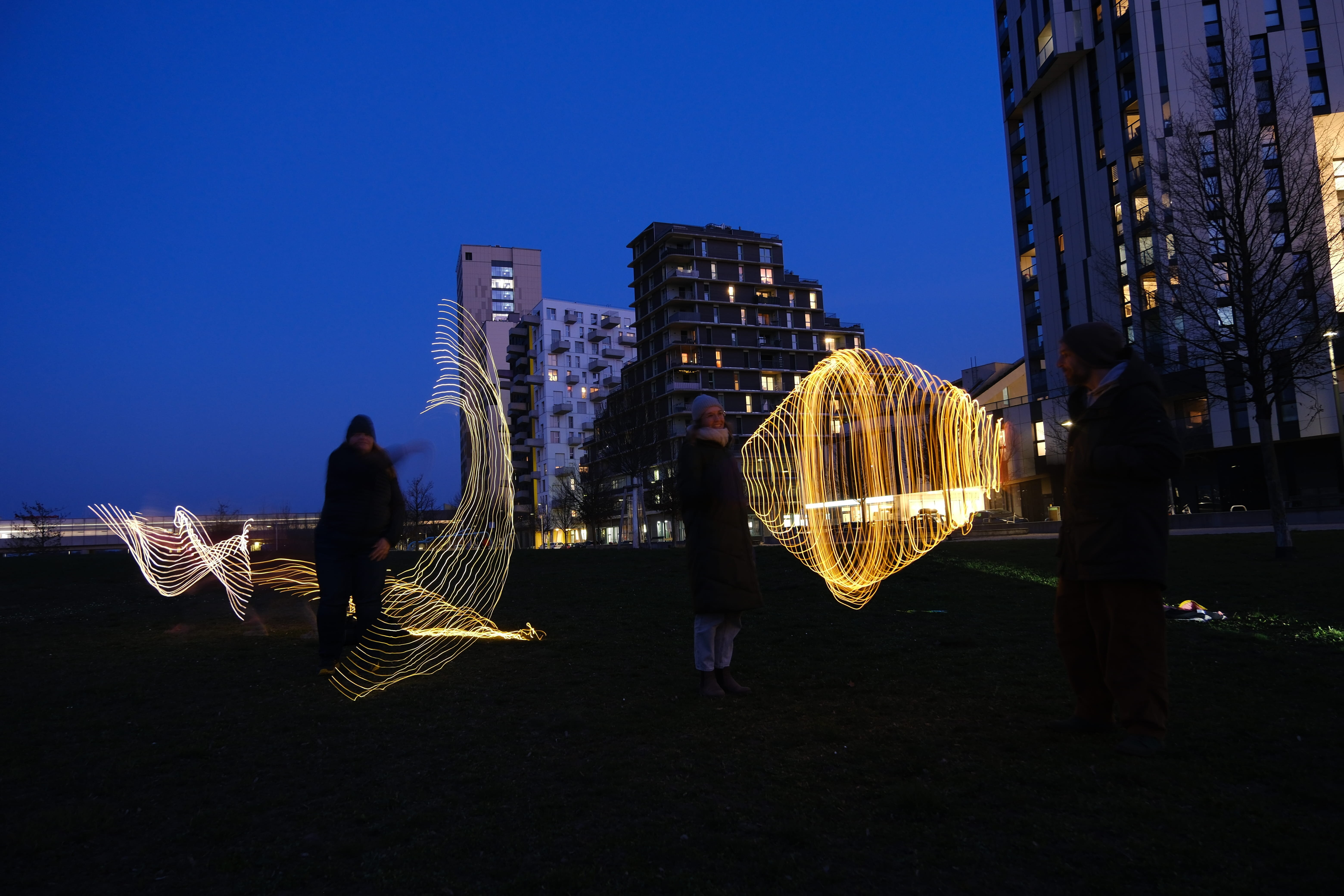 Lichterzeichnungen in der Luft, es ist dunkel, ein Park ist zu sehen