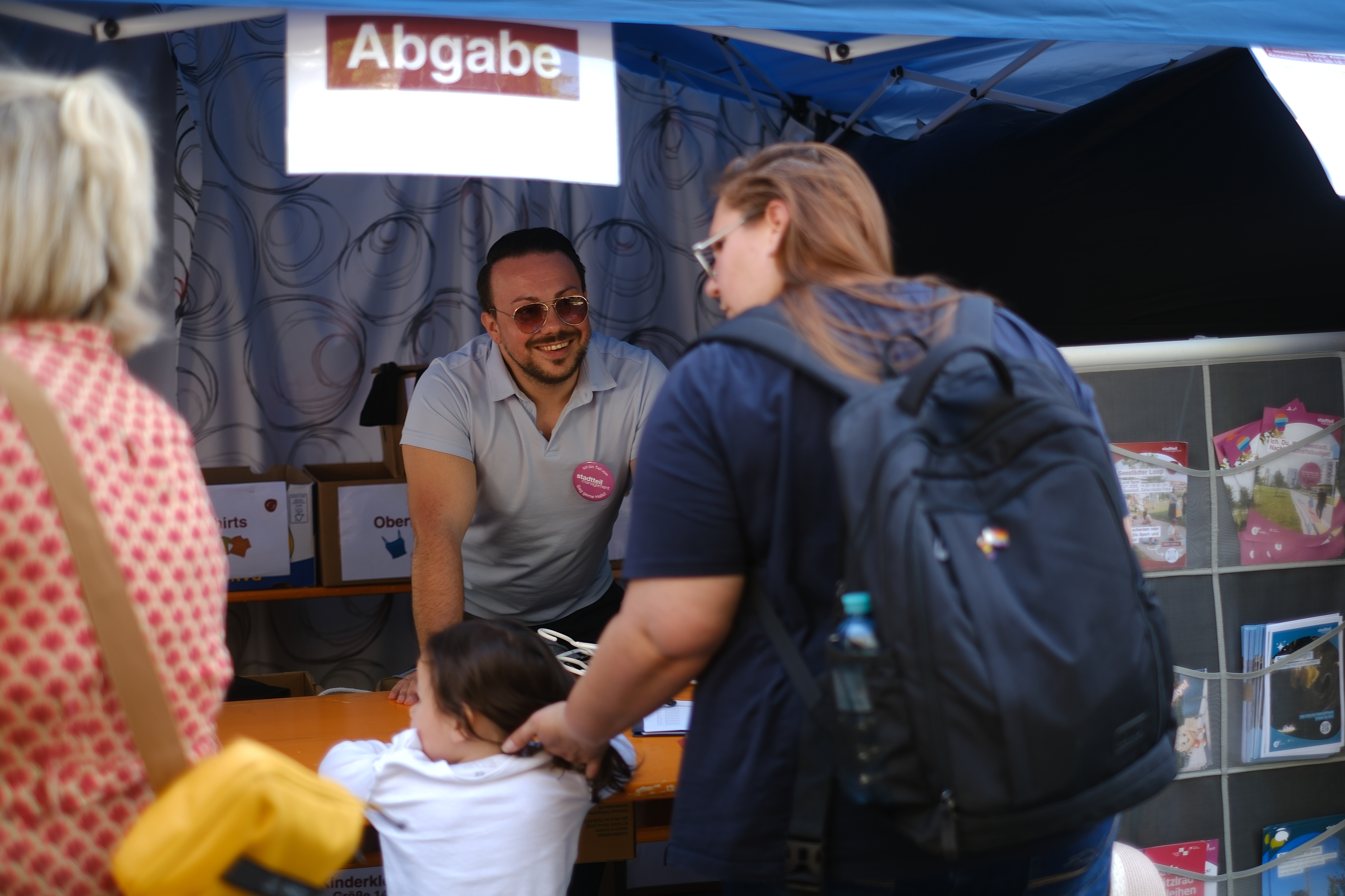 Personen, die Kleidung bei der Abgabestation abgeben