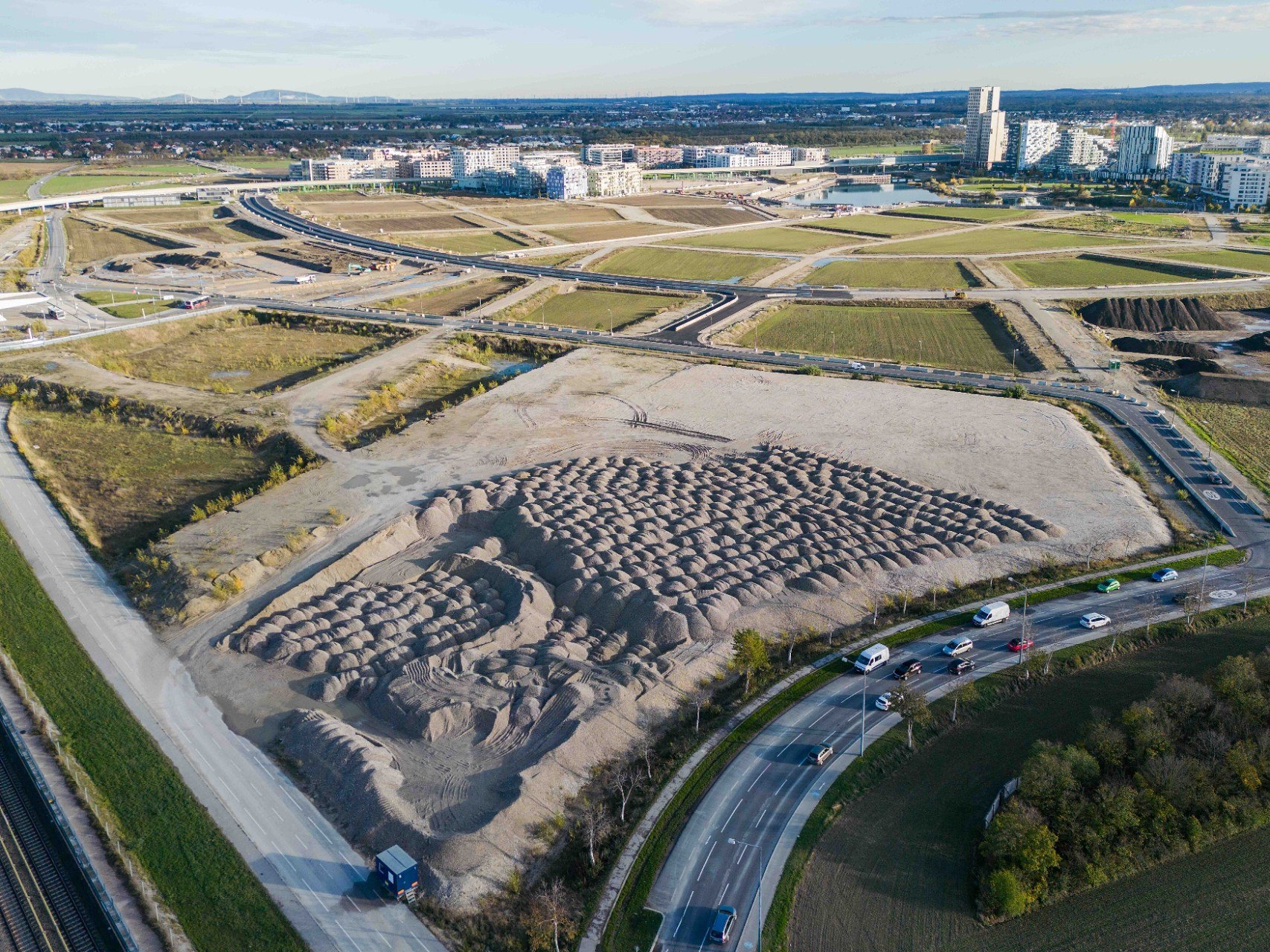 Die intelligente Baustelle in der Seestadt nutzt Kreislaufwirtschaft zur Ressourcenschonung. Drohnenaufnahme einer Baustelle mit vielen Erdhaufen.