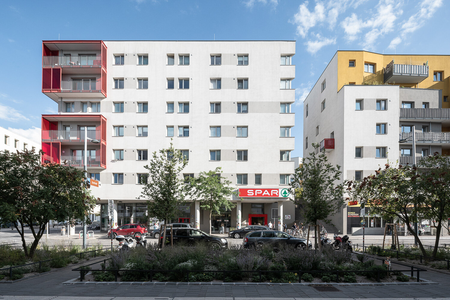 Spar im Pionierquartier aspern Seestadt Grünflächen und Bäume vor einem modernen Haus mit Spar Filiale
