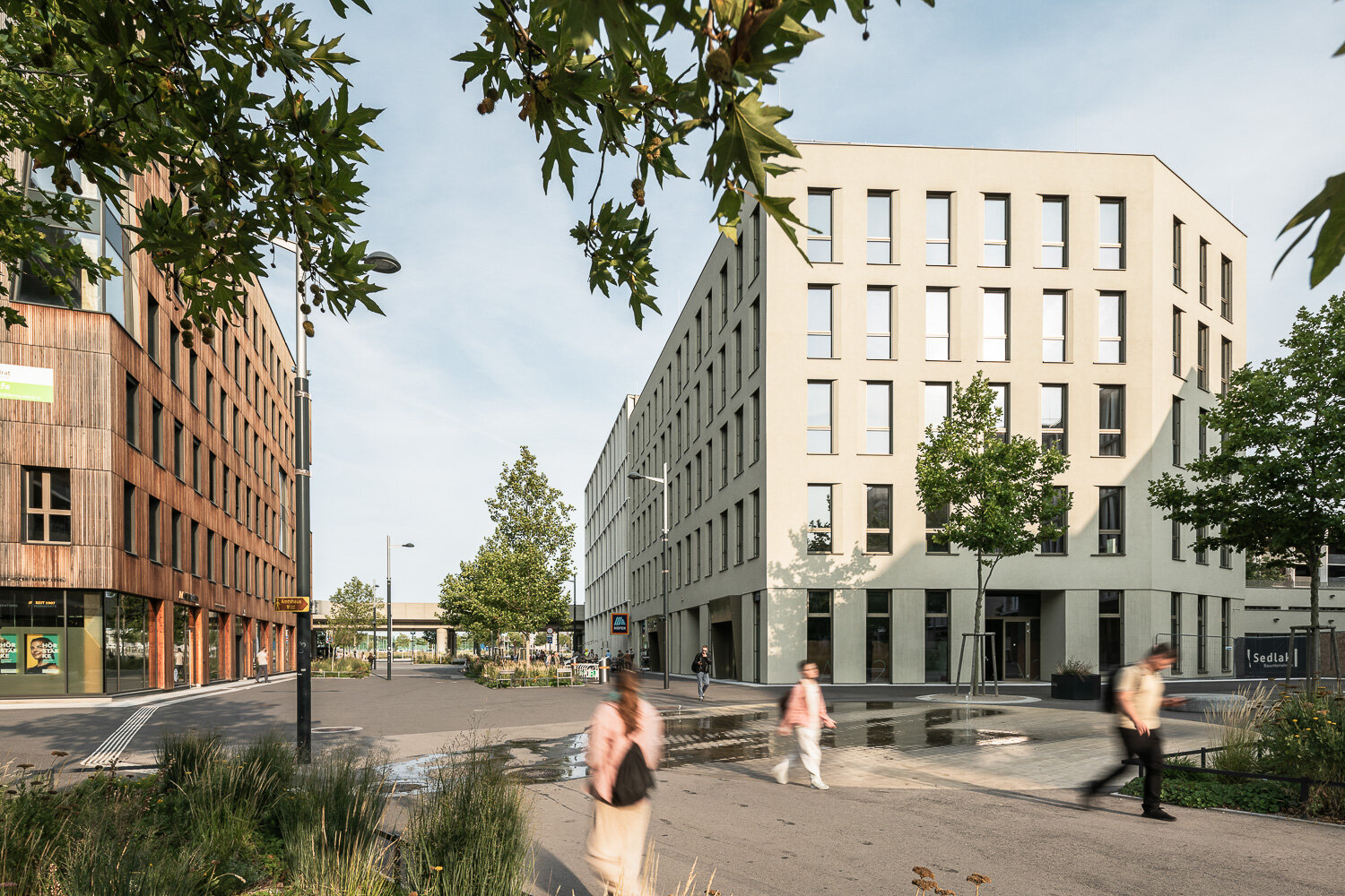 Das NOA22 im Seeparkquartier aspern Seestadt moderner weißer Bürokomplex mit hohen Fenstern direkt in einer Fußgängerzone und an der U-Bahn