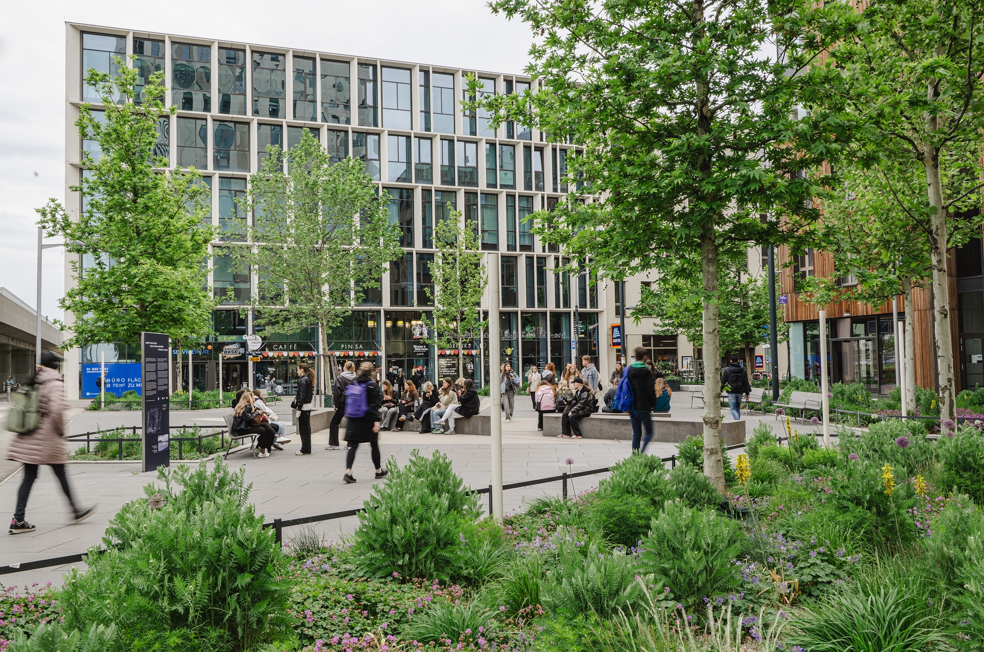 Gebäude SEEHUB mit Personen am Wangari-Maathai-Platz