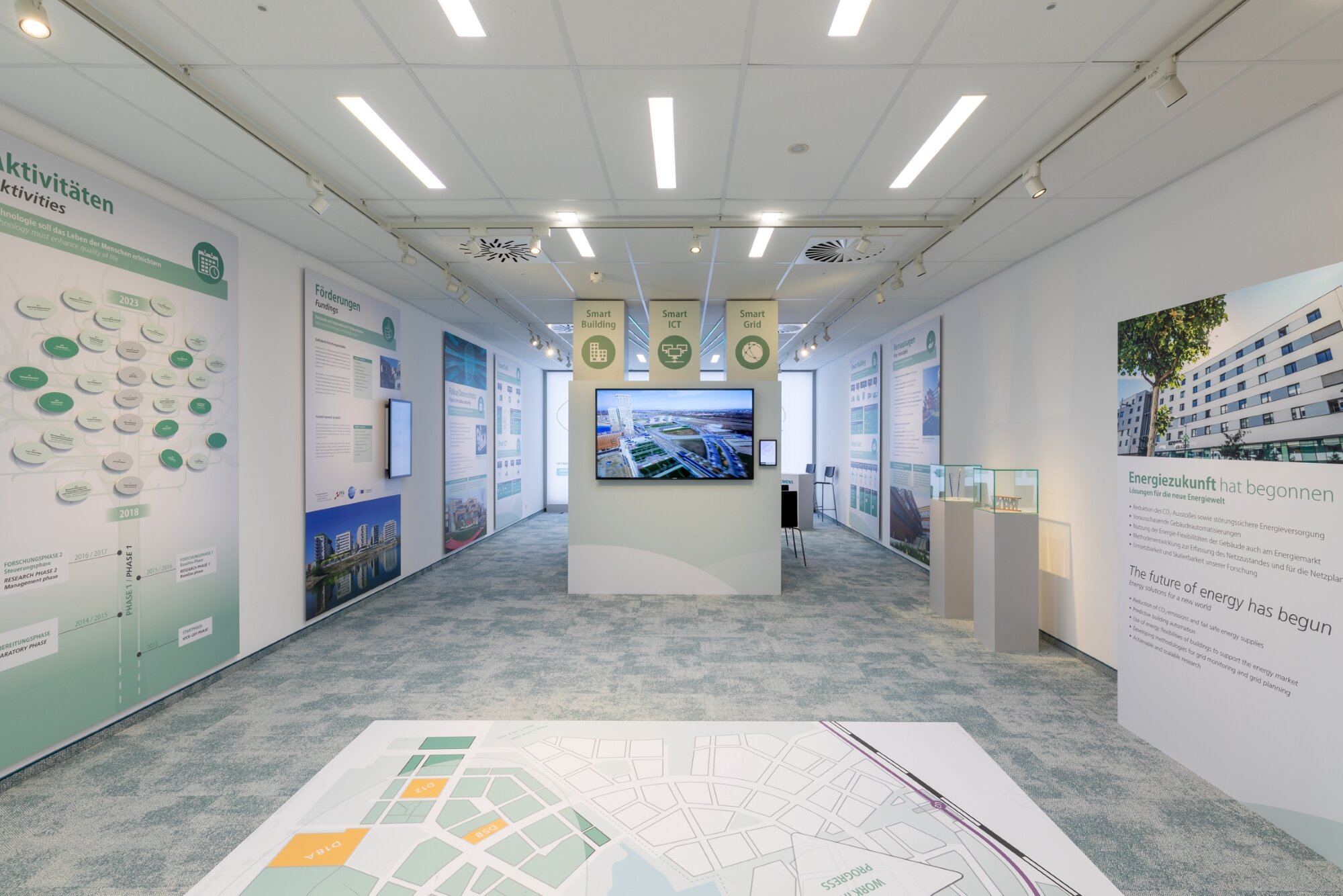 moderner Präsentationsraum mit Informationen an Wänden, Boden und Bildschirm der ASCR