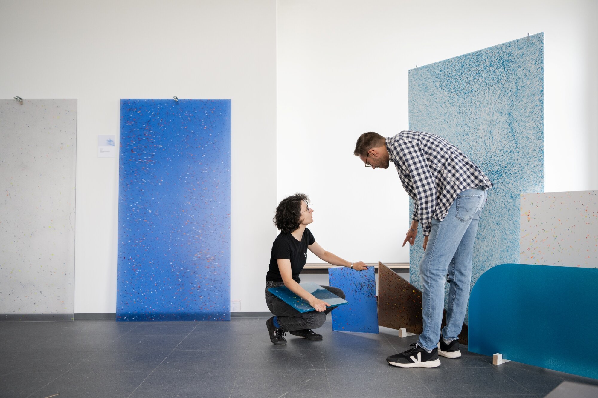 Frau und Mann inspizieren Design-Platten aus Kunststoffabfällen