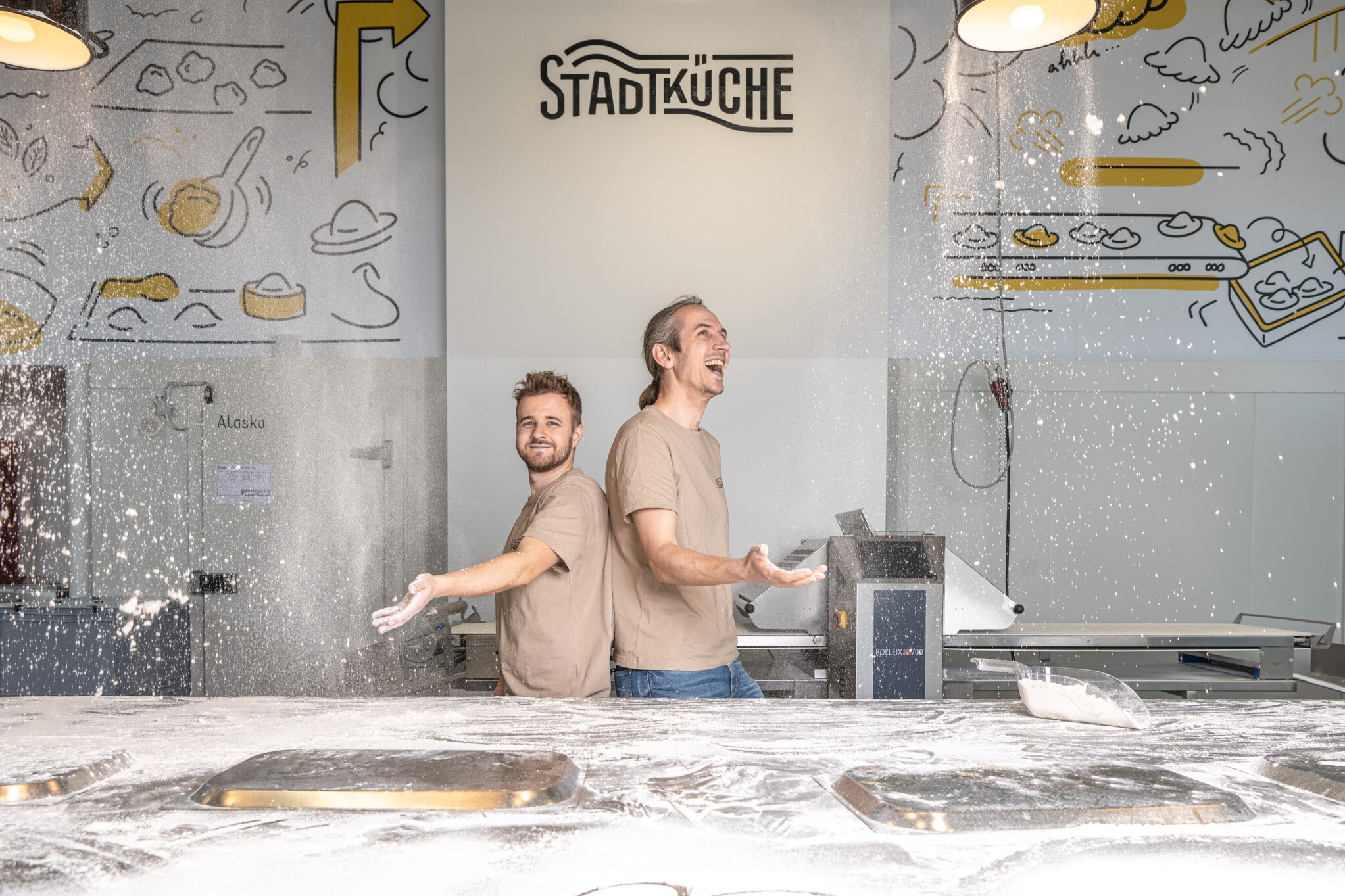 zwei Männer haben Spaß an der Produktion von Kasnudeln in ihrem Betrieb mitten in der Stadt