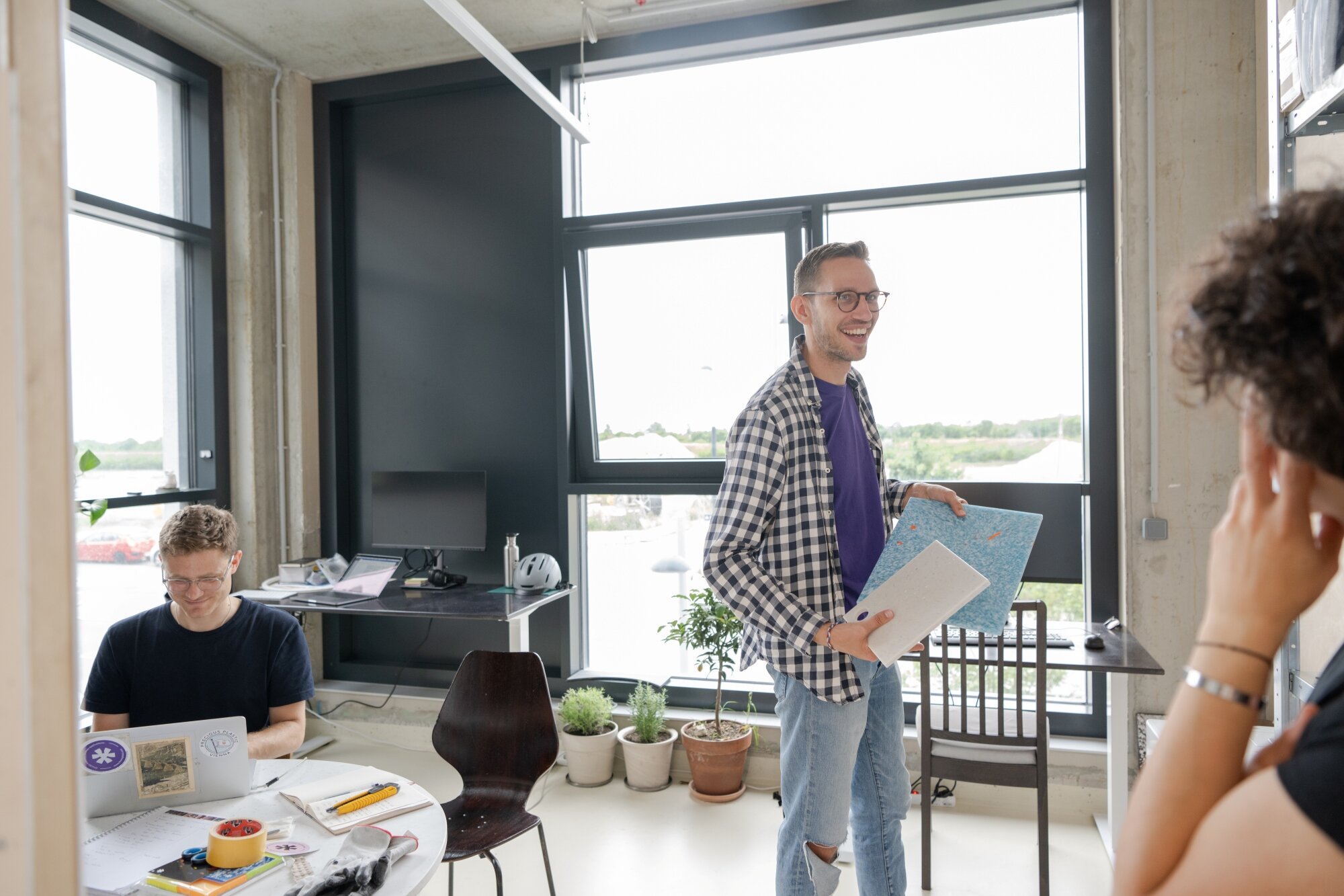 Fantoplast entwickelt Designplatten aus Altplastik ein kleines Team arbeitet an Designplatten aus Altplastik in einem schlichten Büro