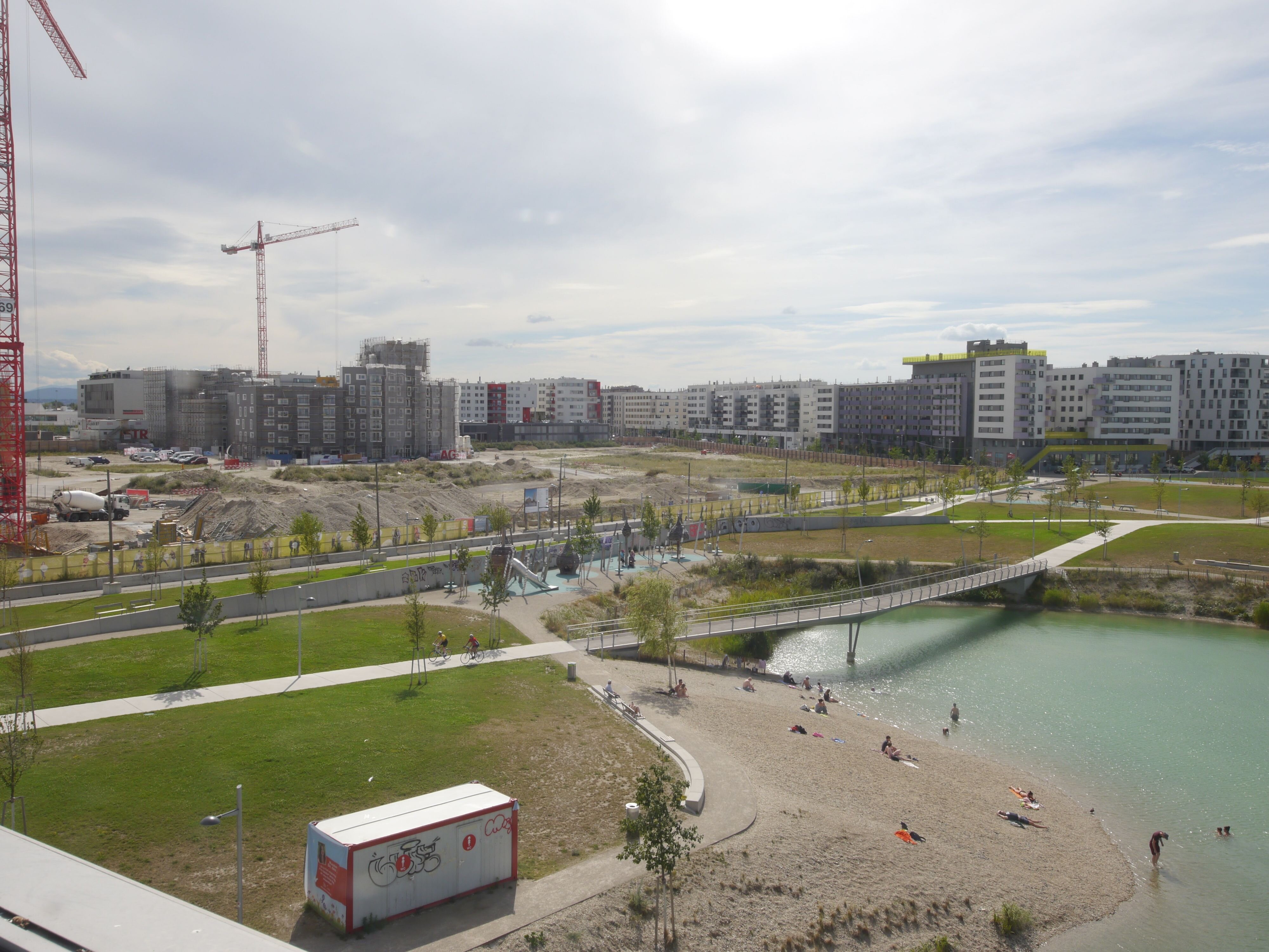 Das Bild zeigt den Seepark im Vordergrund und die Baustelle Seeparkquartier im Hintergrund. 