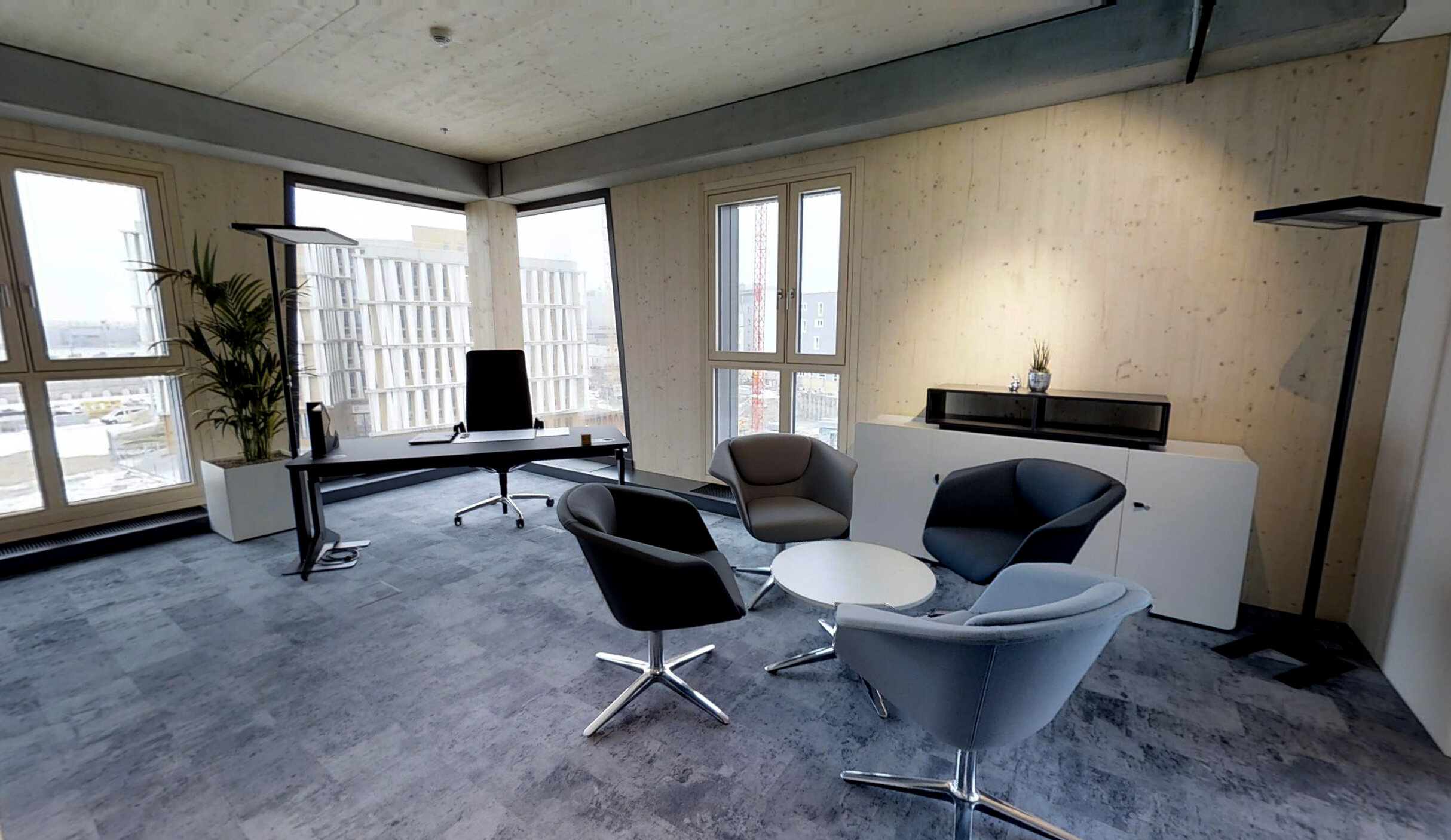 Musterbüro im HoHo Wien mit Holzwänden und Holzdecke, graue Möblierung.