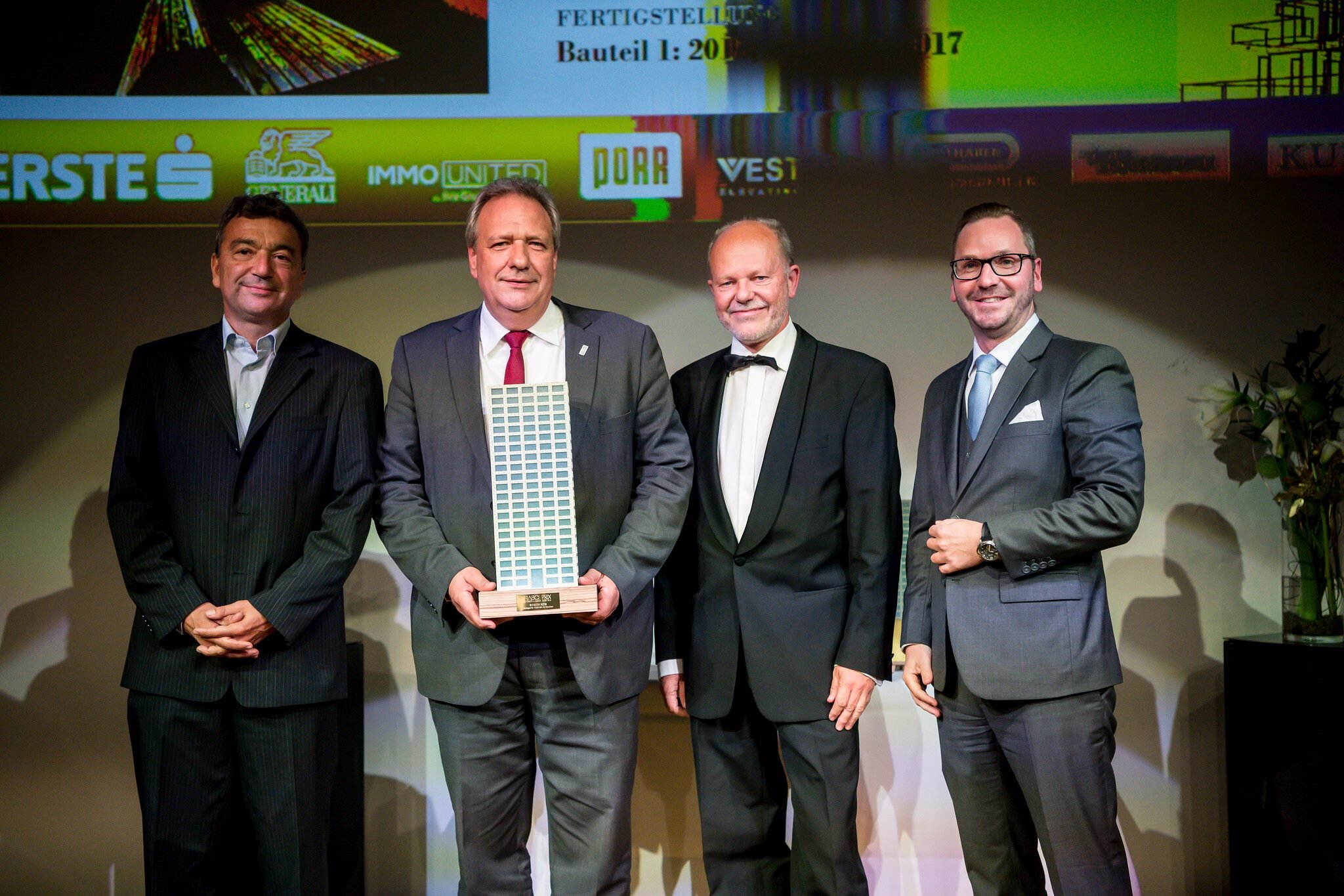 Vier Männer bei einer Preisverleihung. 