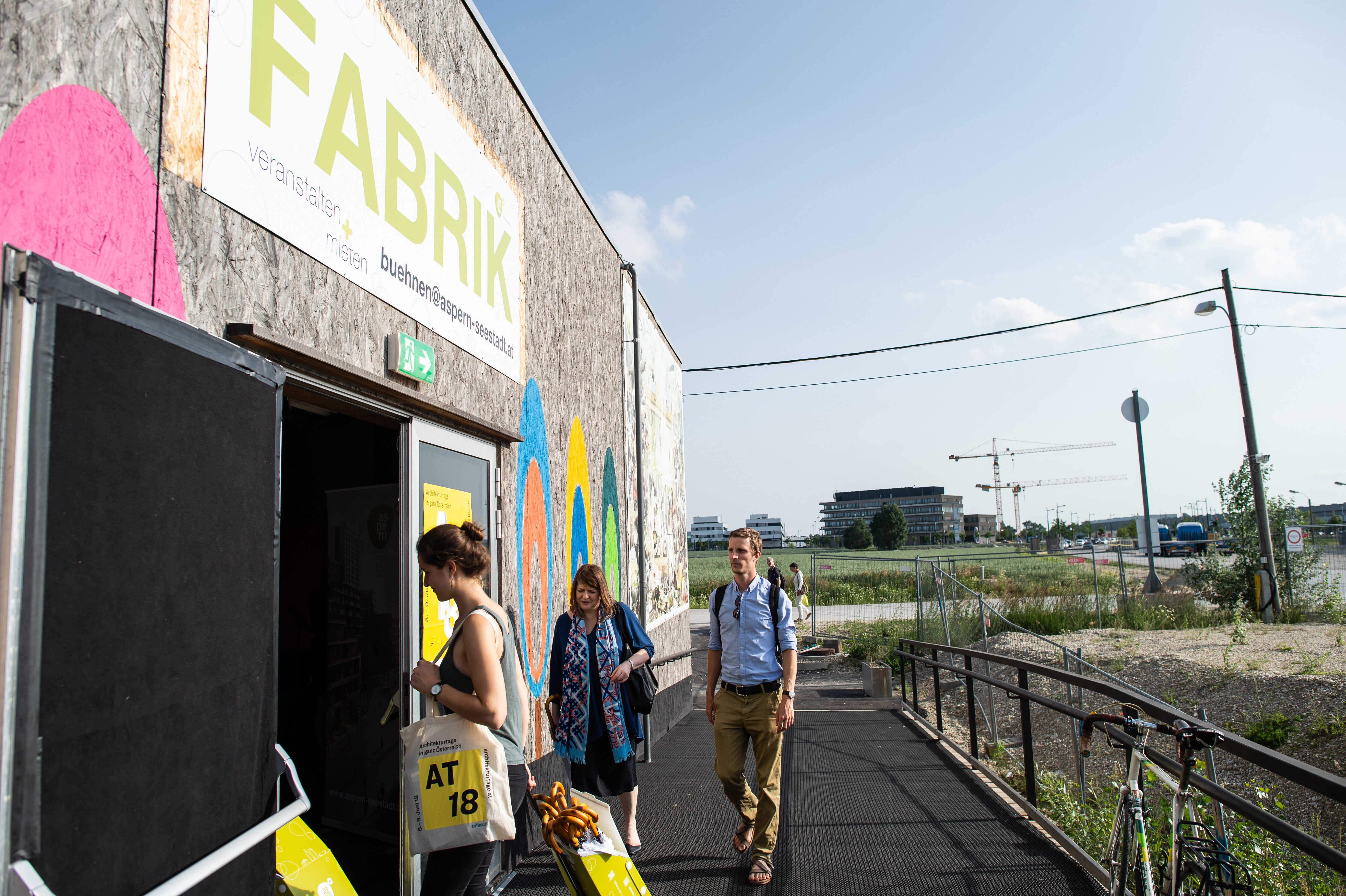 Veranstaltungshalle von außen mit Holzfassade und Aufschrift FABRIK