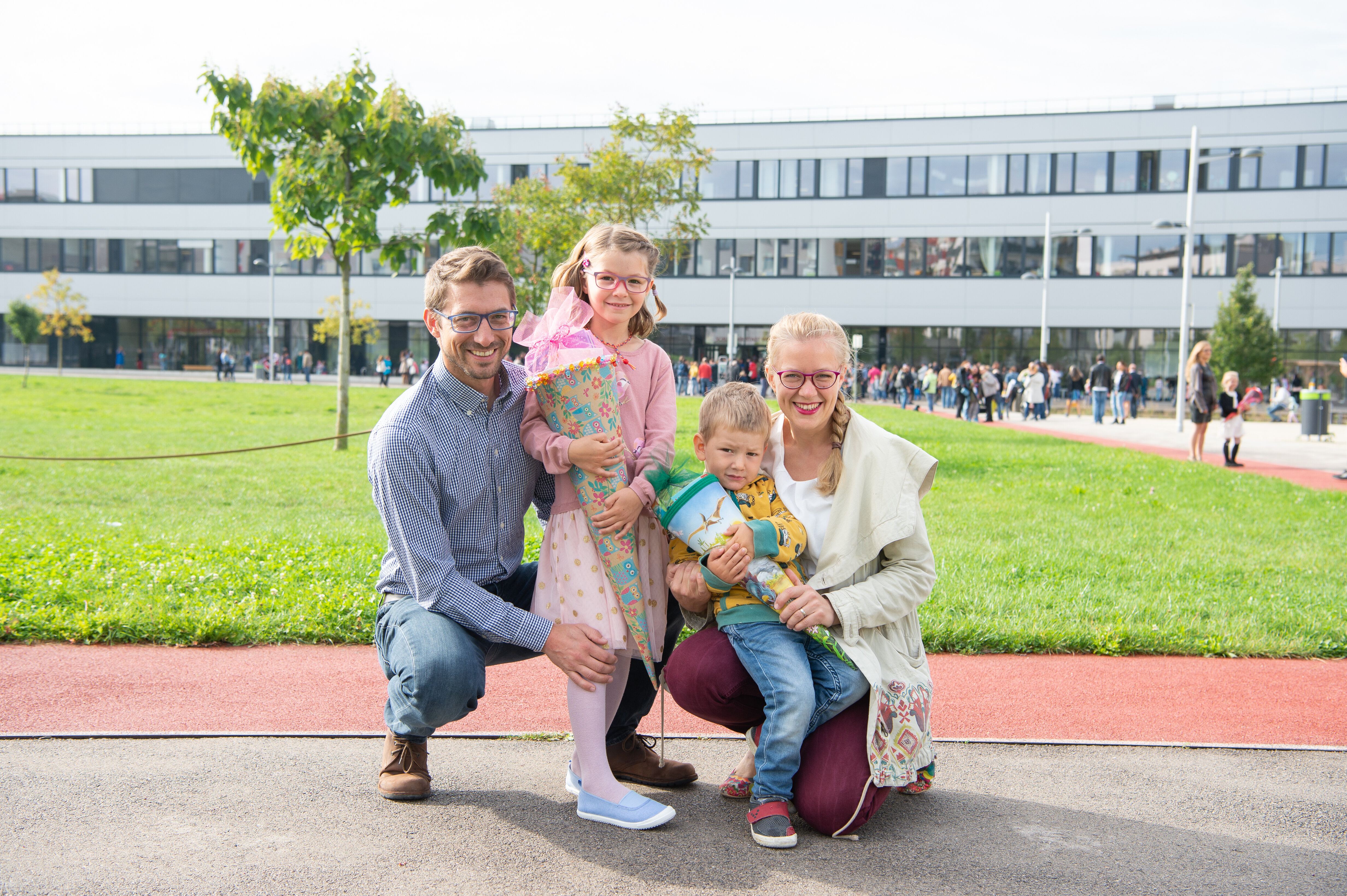 Eltern mit ihren zwei Kindern die jeweils eine Schultüte in der Hand haben