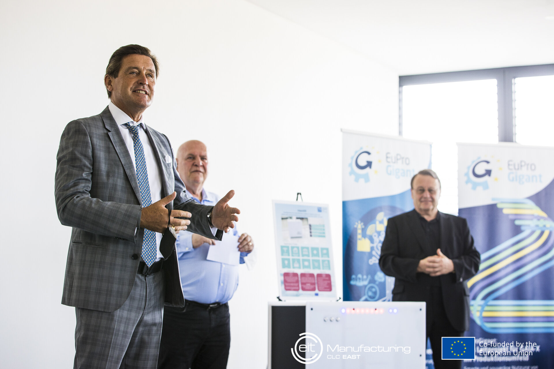 Peter Hanke sprechend, im Hintergrund zwei Männer