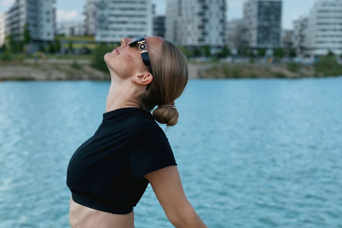 Frau in Yoga-Pose, im Hintergrund See