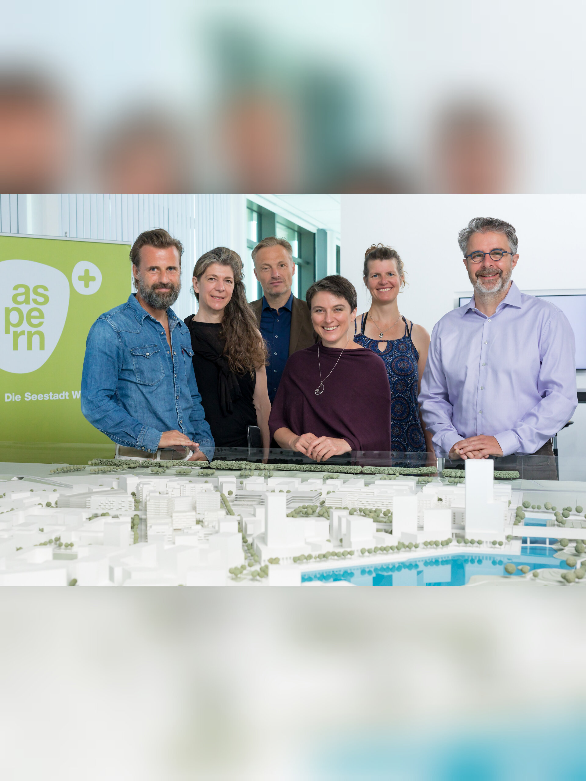 Sechs Personen vor einem Modell der Seestadt.