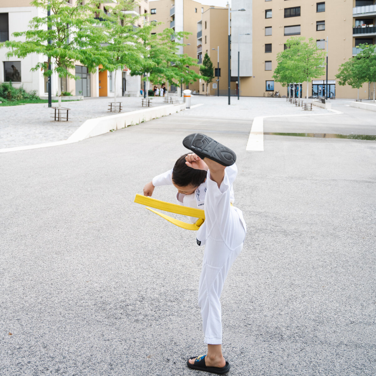 Junge in weißem Kampfanzug macht einen Kick