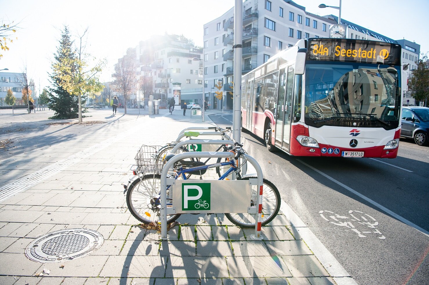Bus 84A  fährt auf der Straße an Fahrrädern vorbei.