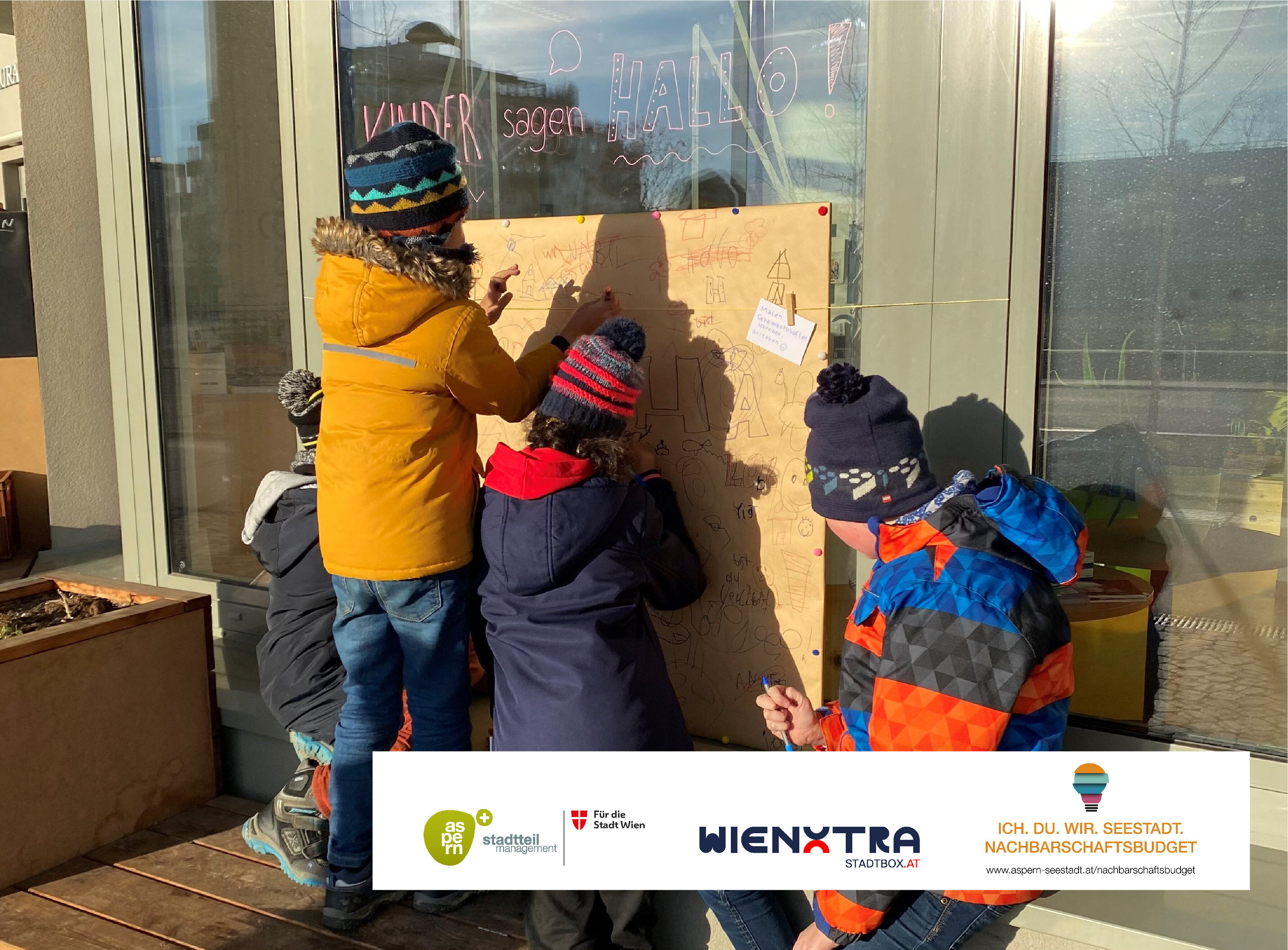 Auf dem Bild sieht man Kinder eine Leinwand bemalen