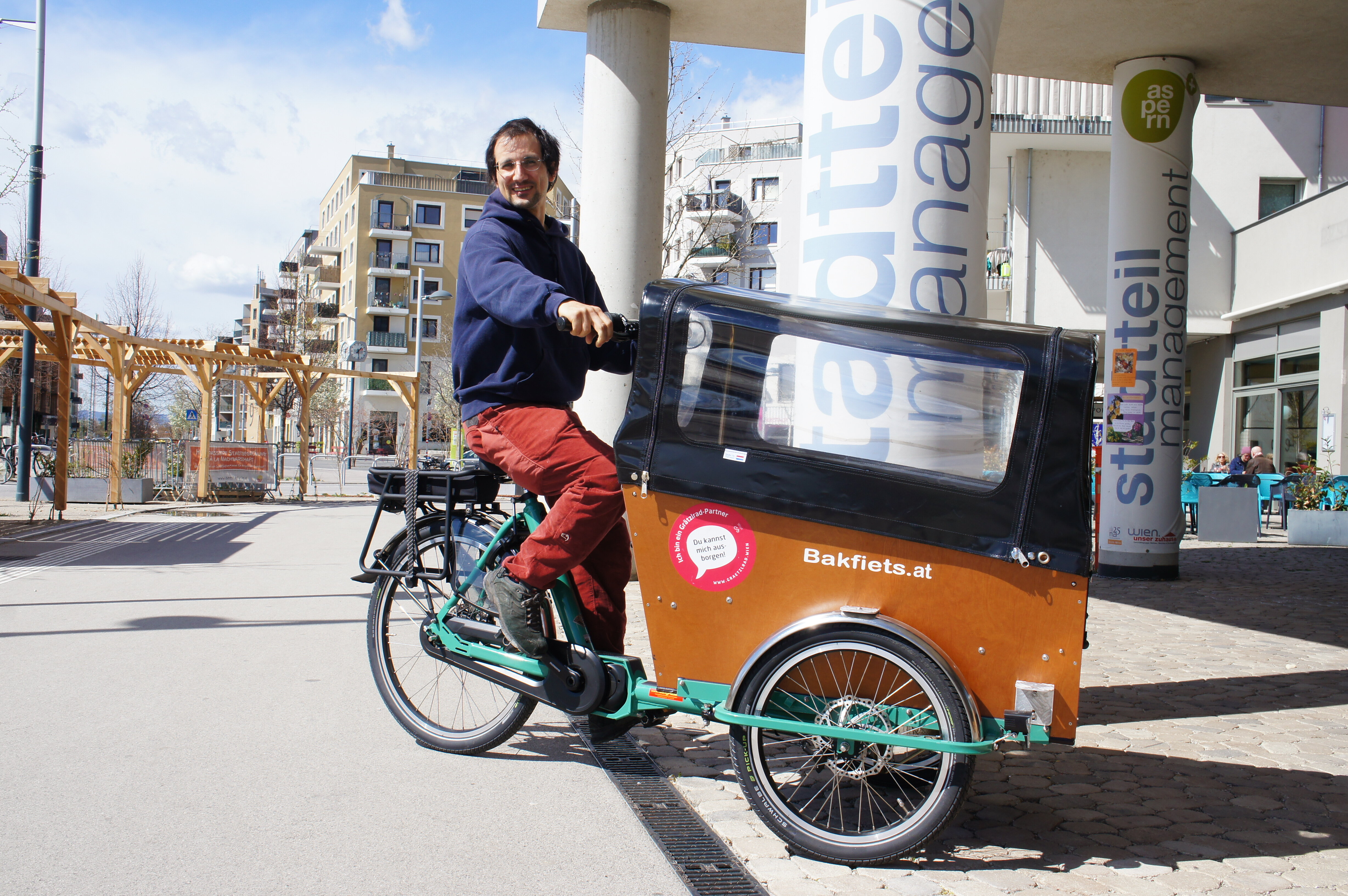 Auf dem Lastenrad sitzt ein Mann