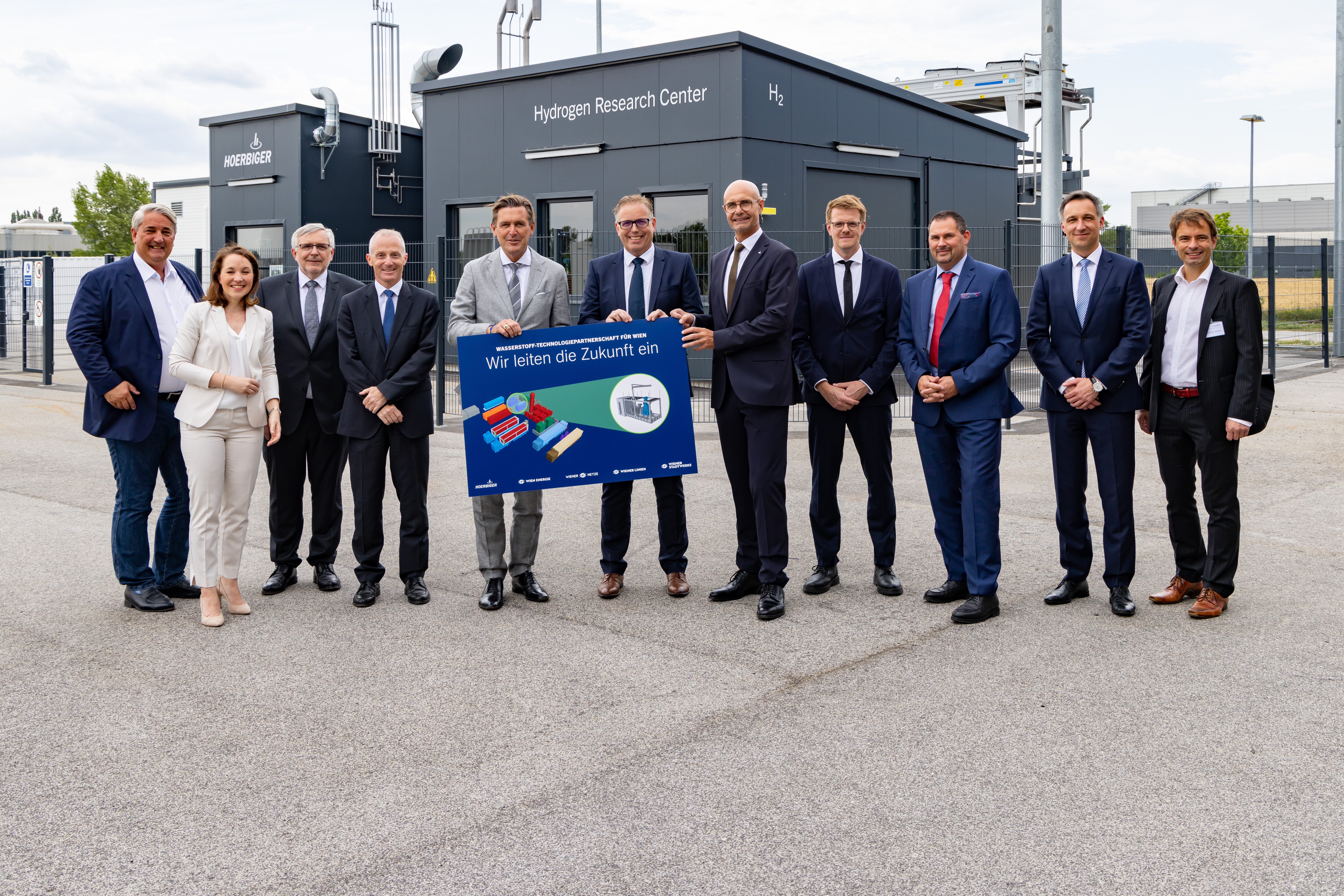 Gruppenfoto der Vertragsabschlusspartner mit Informationenschild