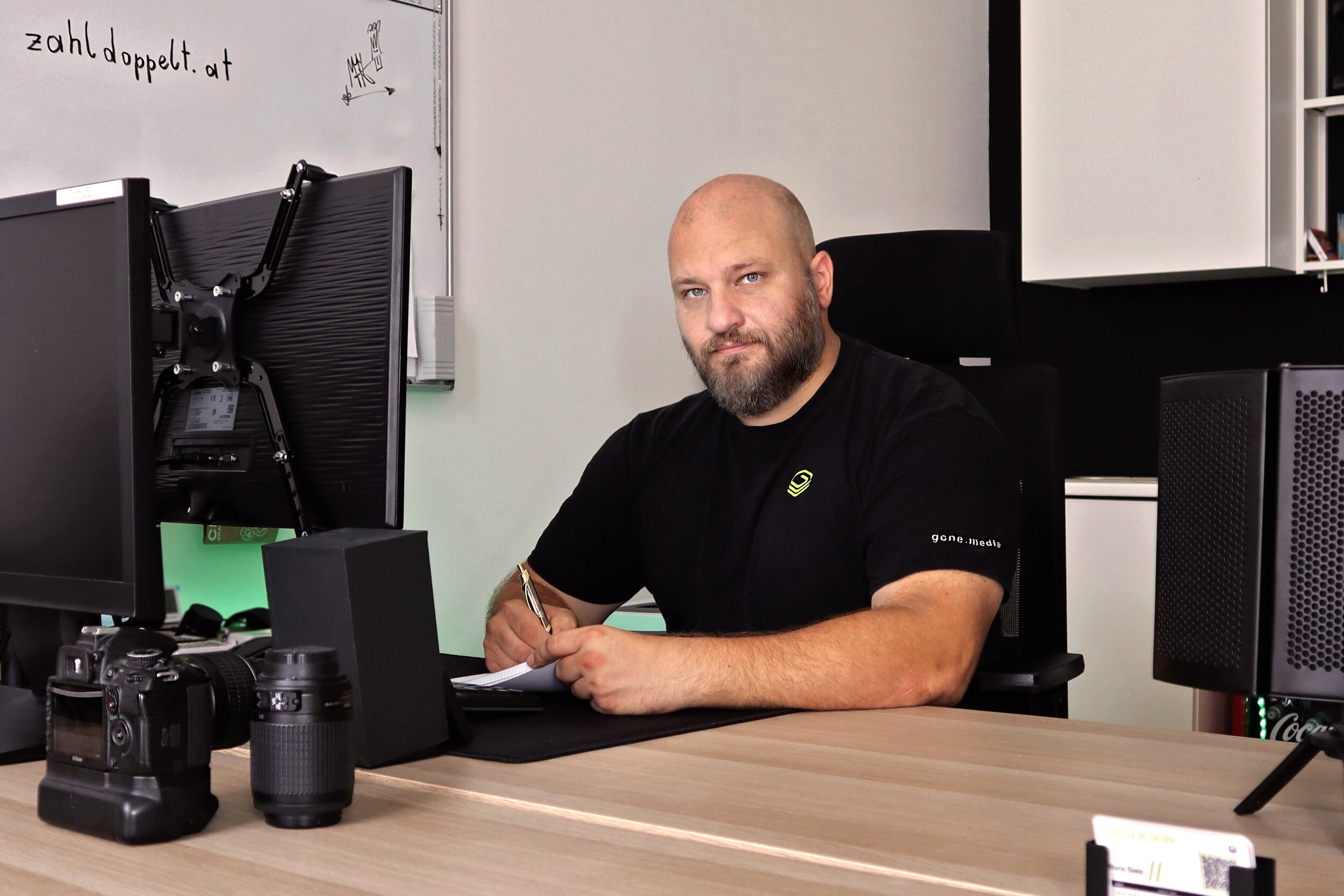 Mann sitzt an seinem Arbeitsplatz vor seinem Computer. 
