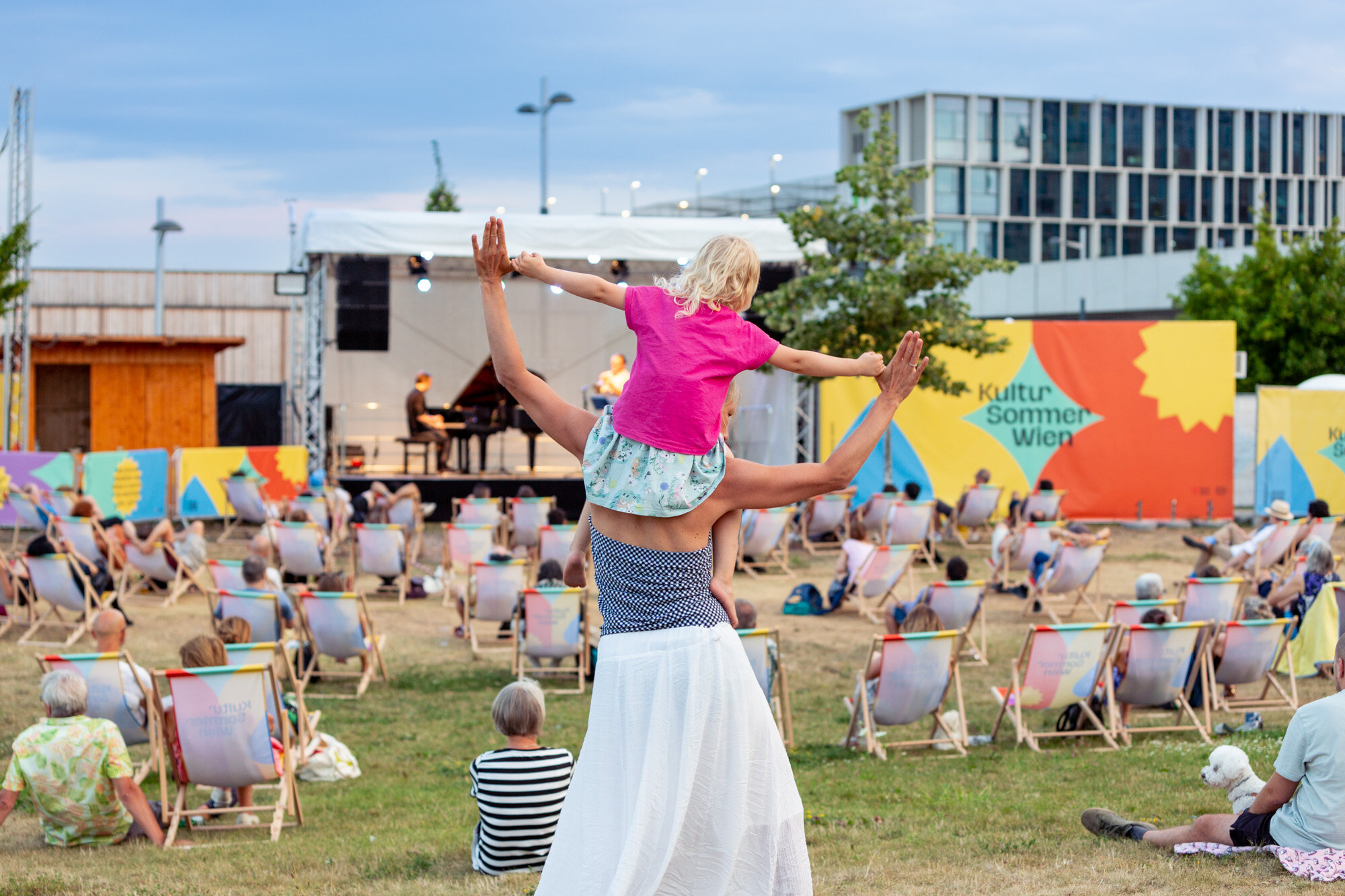 Frau tanzt mit Kind auf den Schultern