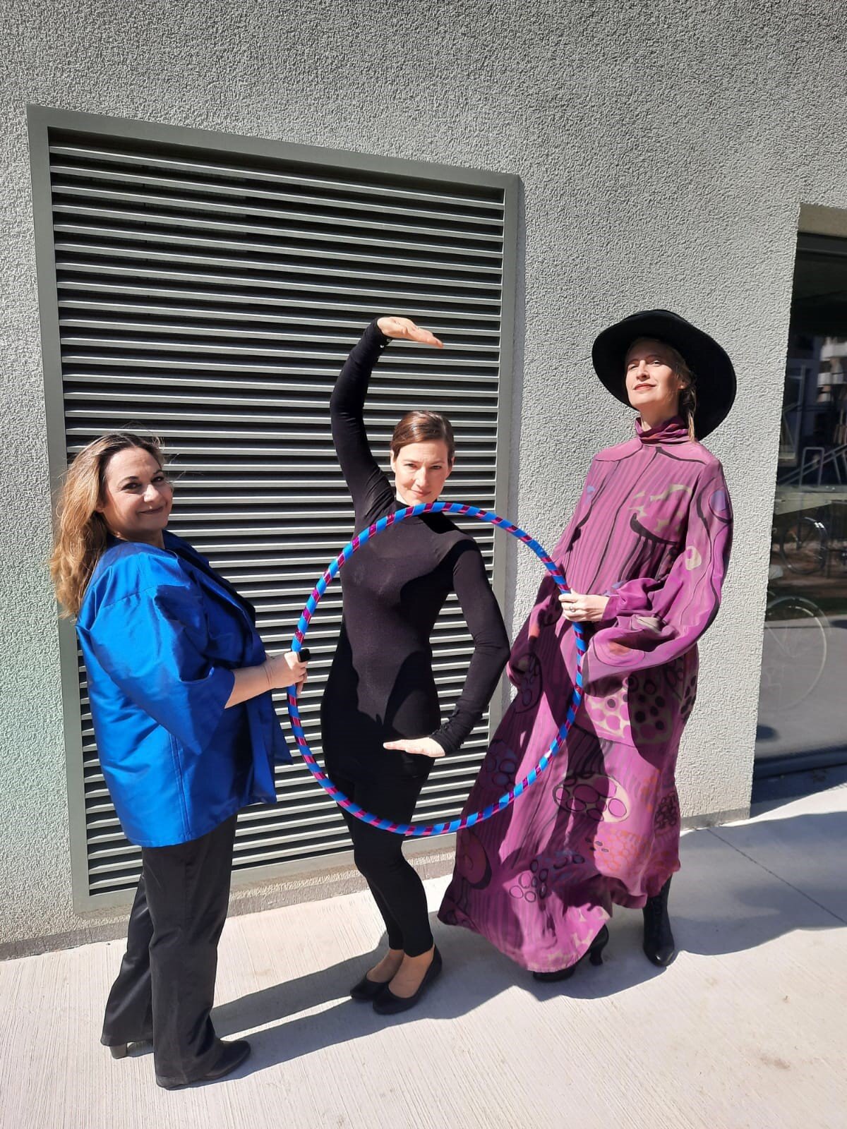 3 Frauen stehen verkleidet als Namensgeber*innen der Straßennamen in der Seestadt vor einer Hauswand