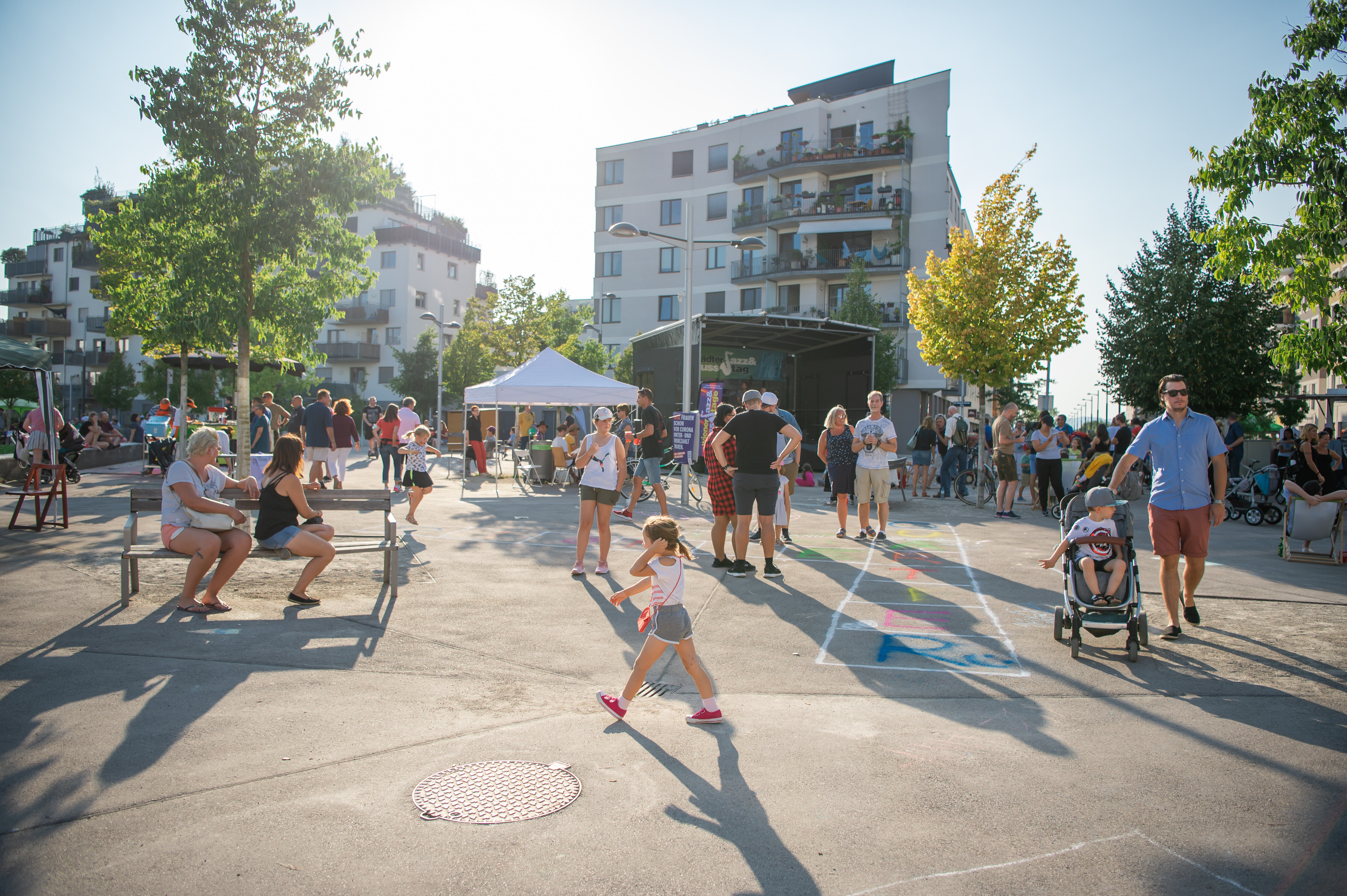 Ein belebert Platz mit spielenden Kindern und festlicher Stimmung.