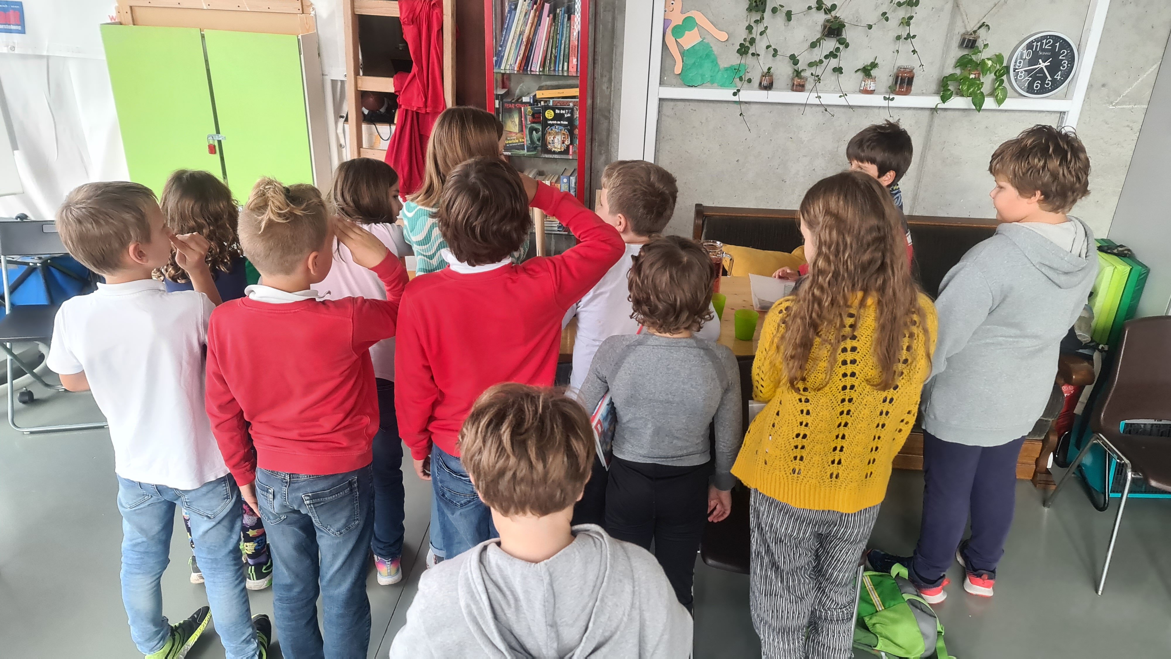 Zehn Kinder stehen um einen Tisch herum, auf dem gespielt wird