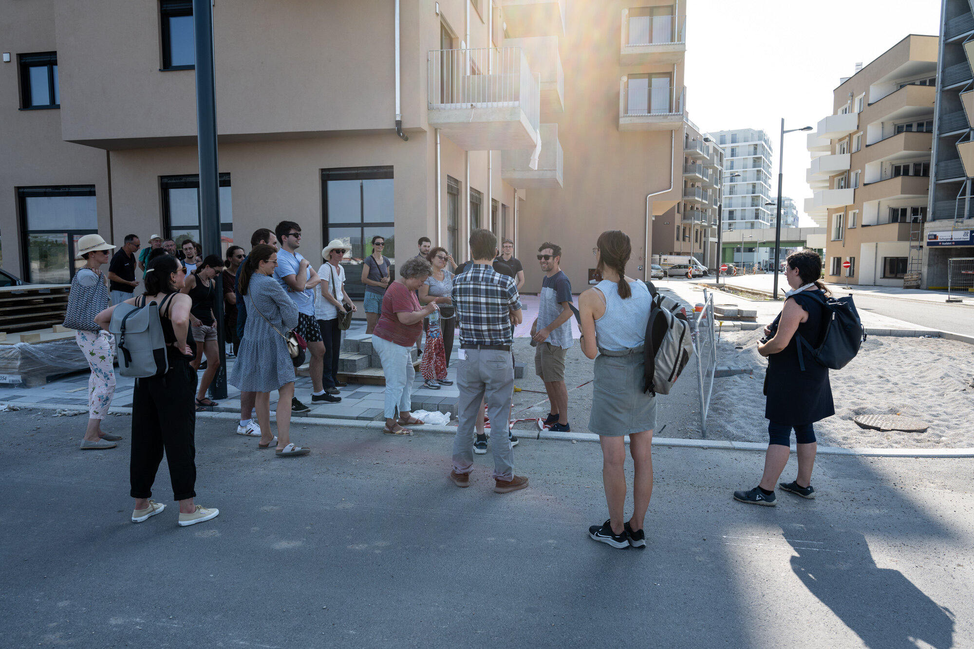 Eine Gruppe von Menschen steht vor einem neuen Gebäude in der Seestadt. 