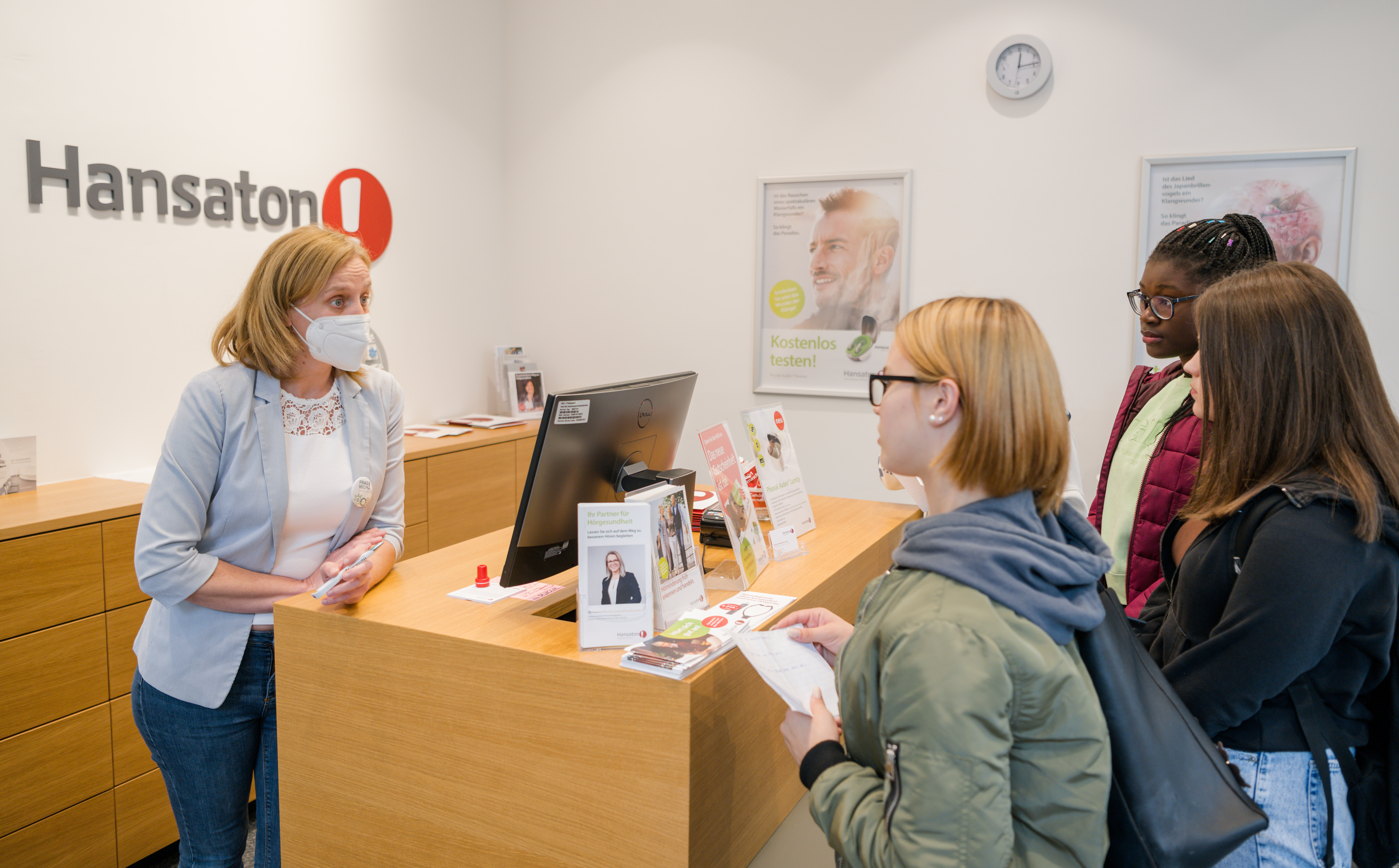 Eine Angestellte von Hörbiger erzählt 3 Jugendlichen etwas