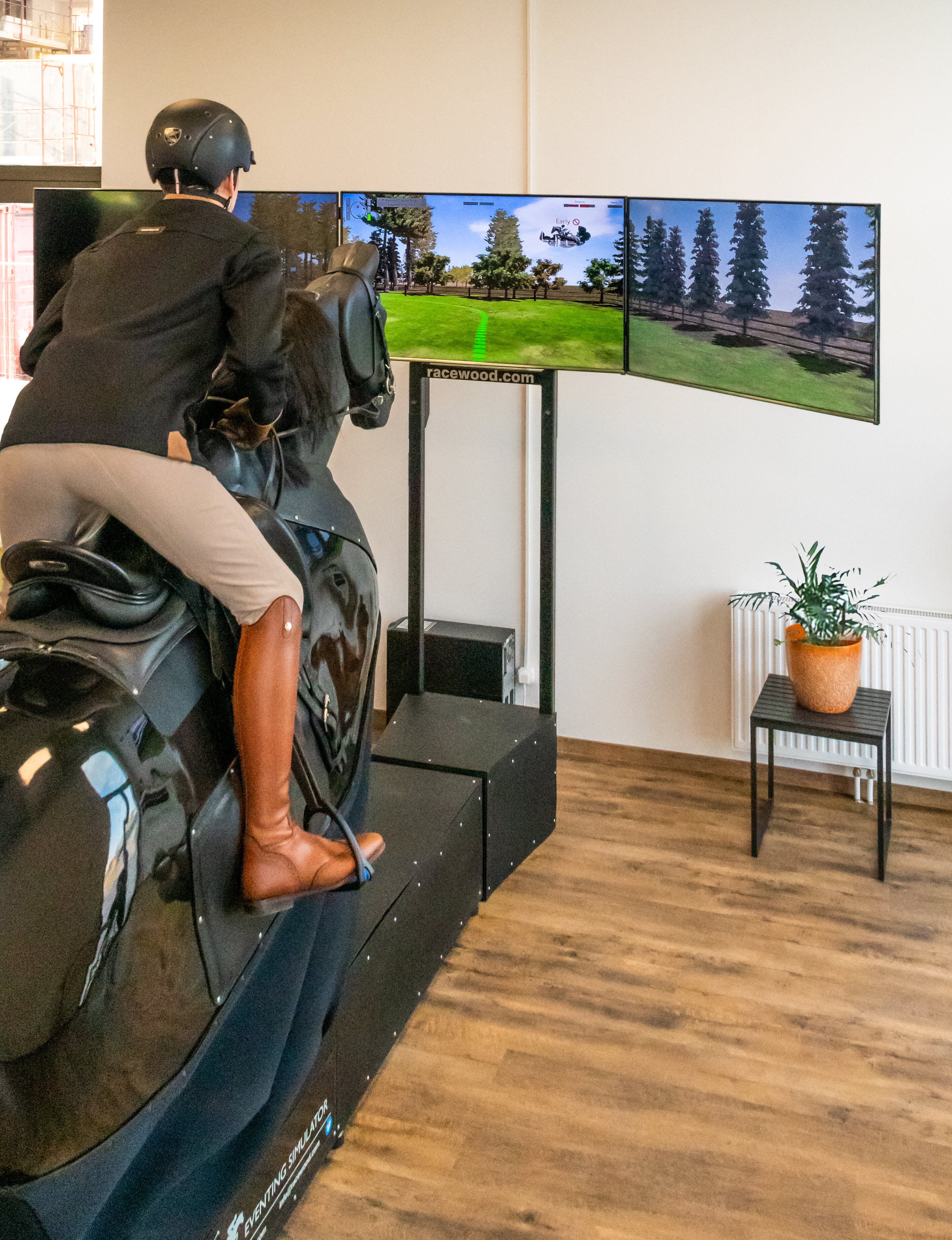 Eine Frau reitet auf einem Reitsimulator, sprich einem unechten Pferd.